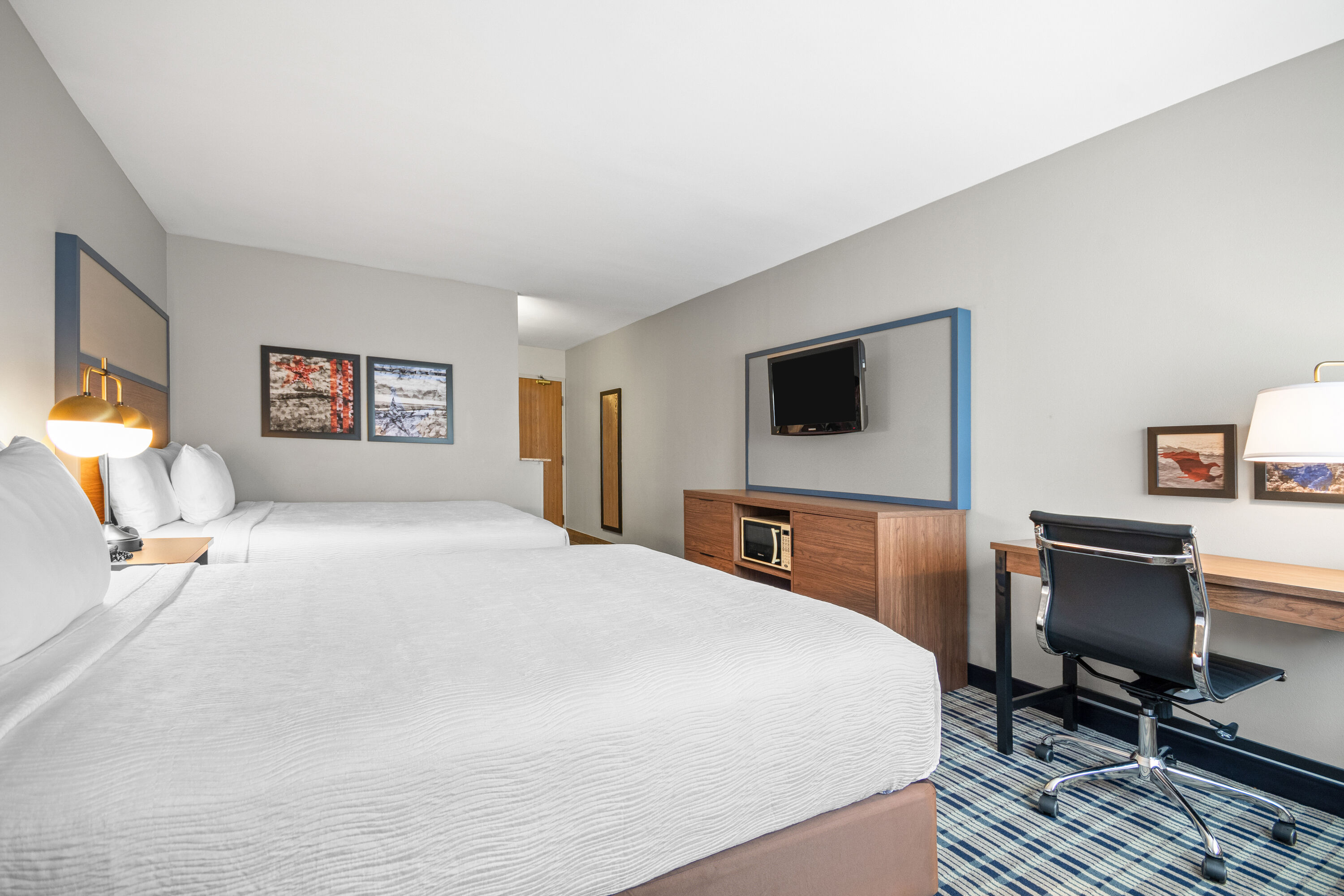 Queen bed guest room at the AmericInn by Wyndham Beloit in Beloit, Wisconsin