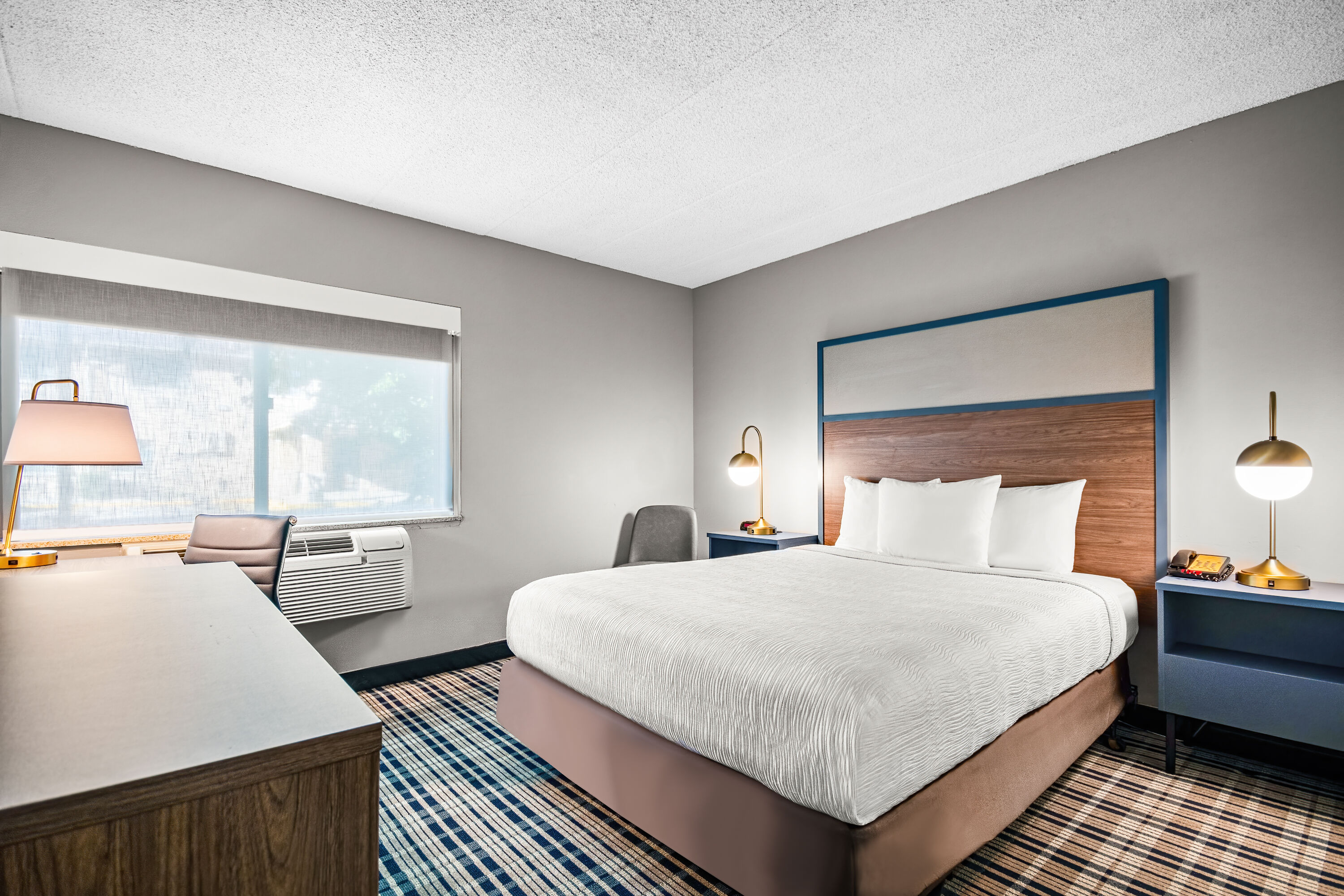 Queen bed guest room at the AmericInn by Wyndham Beloit in Beloit, Wisconsin
