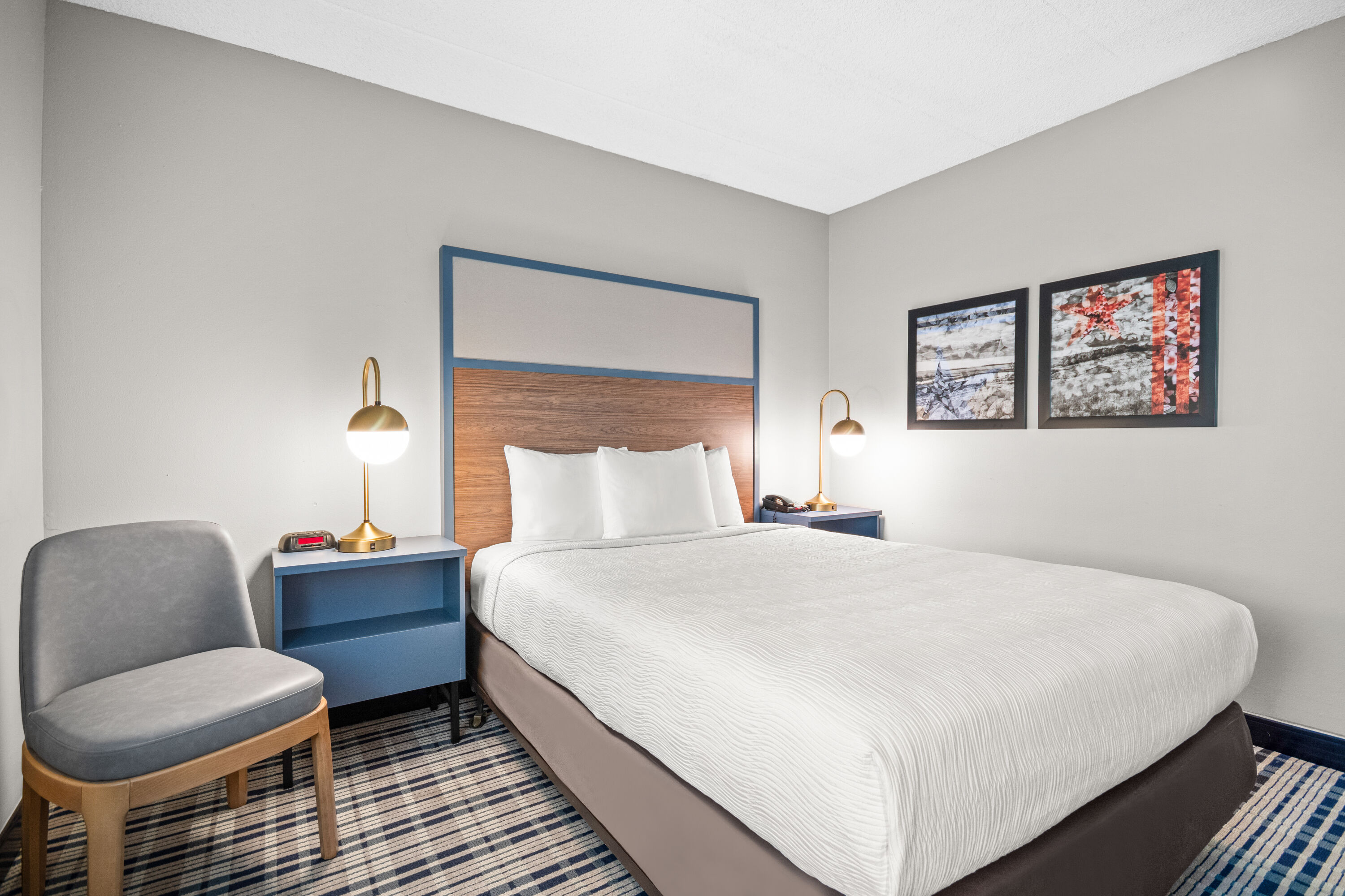 Queen bed guest room at the AmericInn by Wyndham Beloit in Beloit, Wisconsin