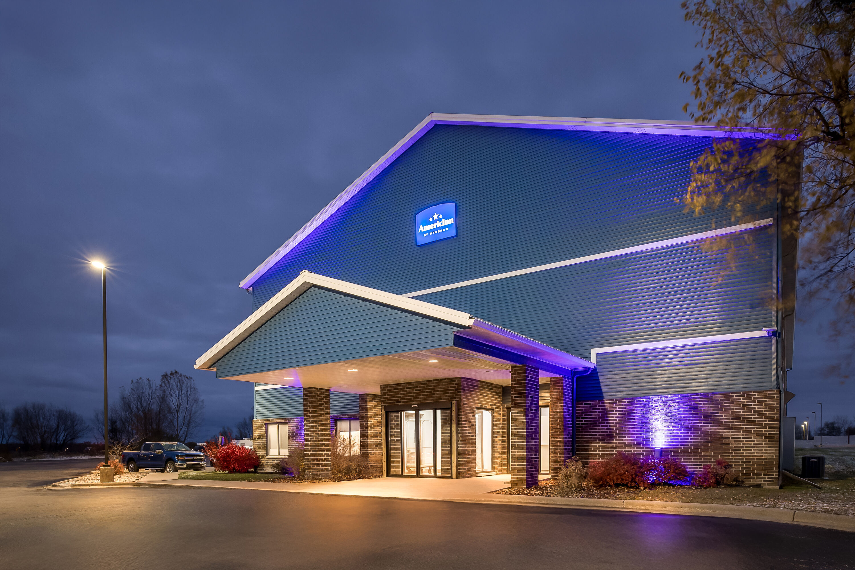 Exterior Night Image of AmericInn by Wyndham Columbus Wisconsin hotel in Columbus, Wisconsin