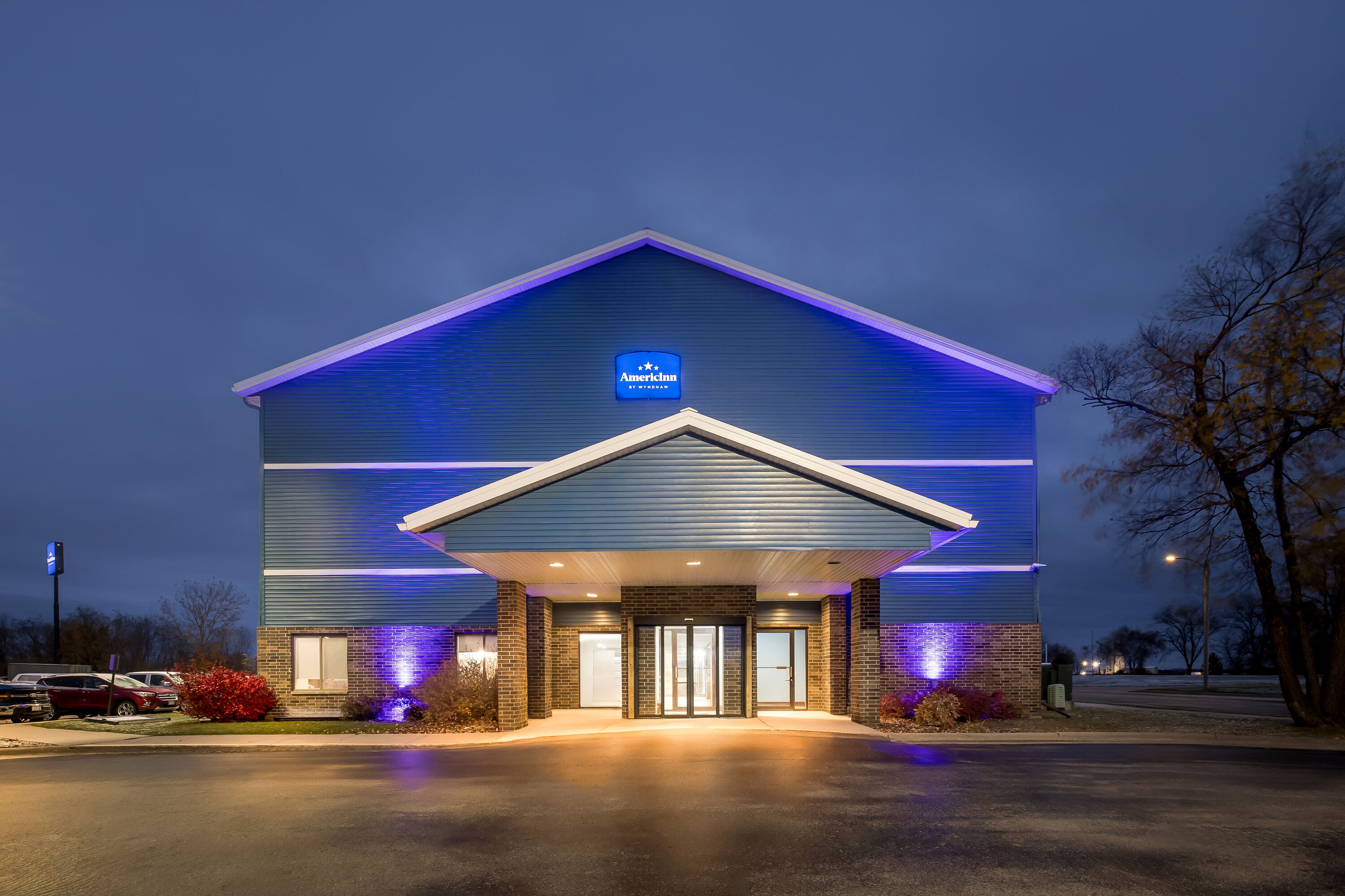 Exterior Night Image of AmericInn by Wyndham Columbus Wisconsin hotel in Columbus, Wisconsin