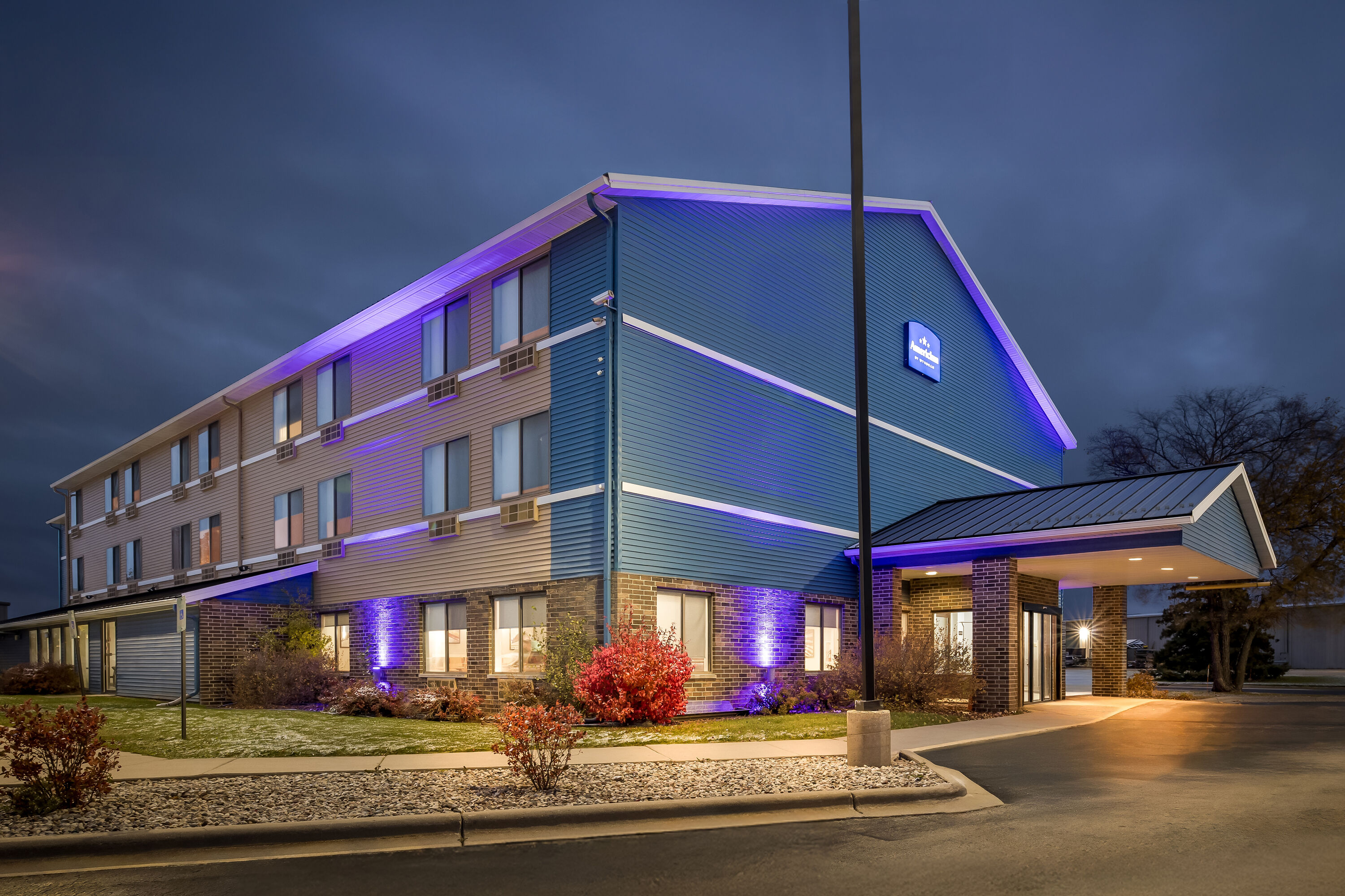 Exterior Night Image of AmericInn by Wyndham Columbus Wisconsin hotel in Columbus, Wisconsin