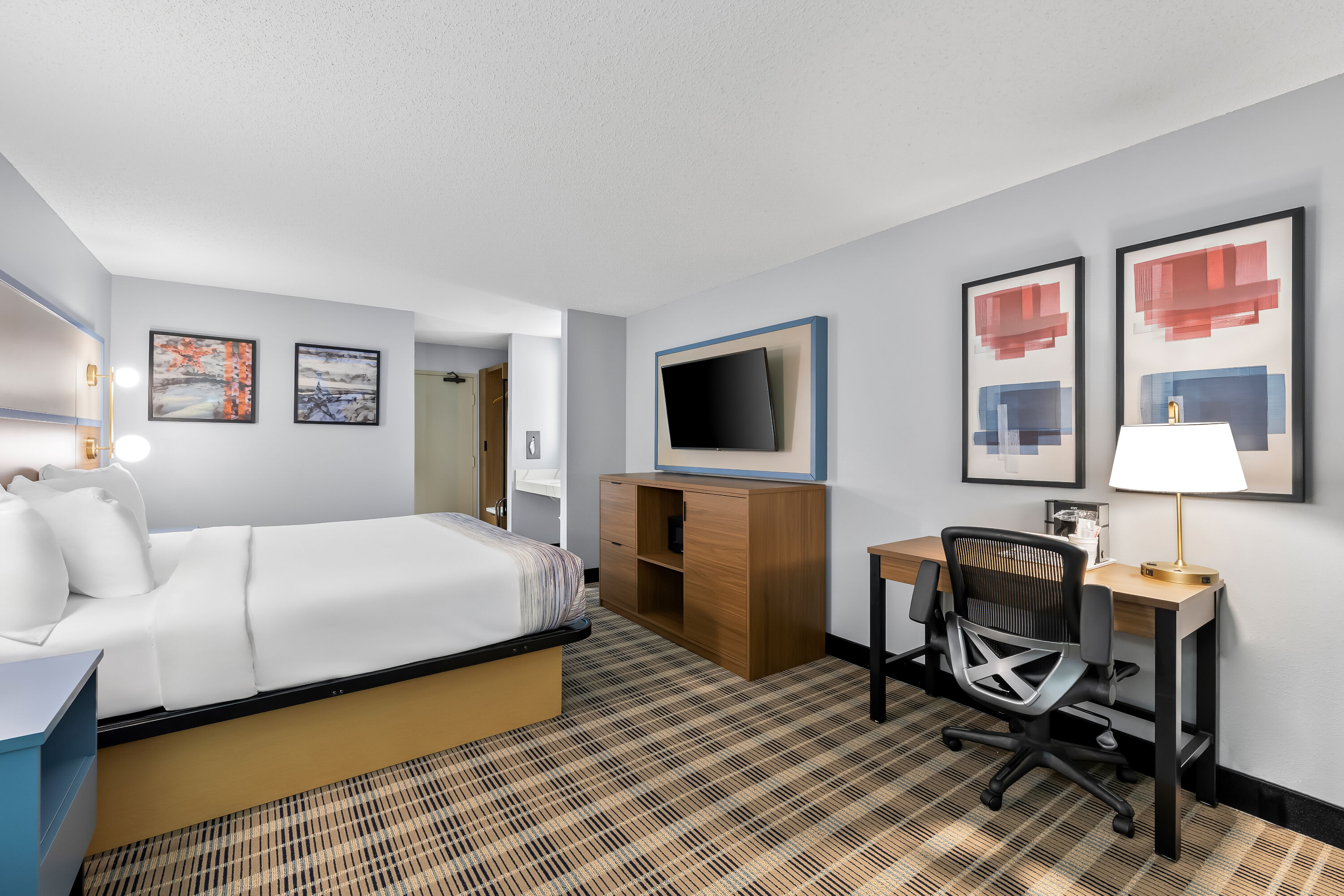 King bed guest room at the AmericInn by Wyndham Columbus Wisconsin in Columbus, Wisconsin