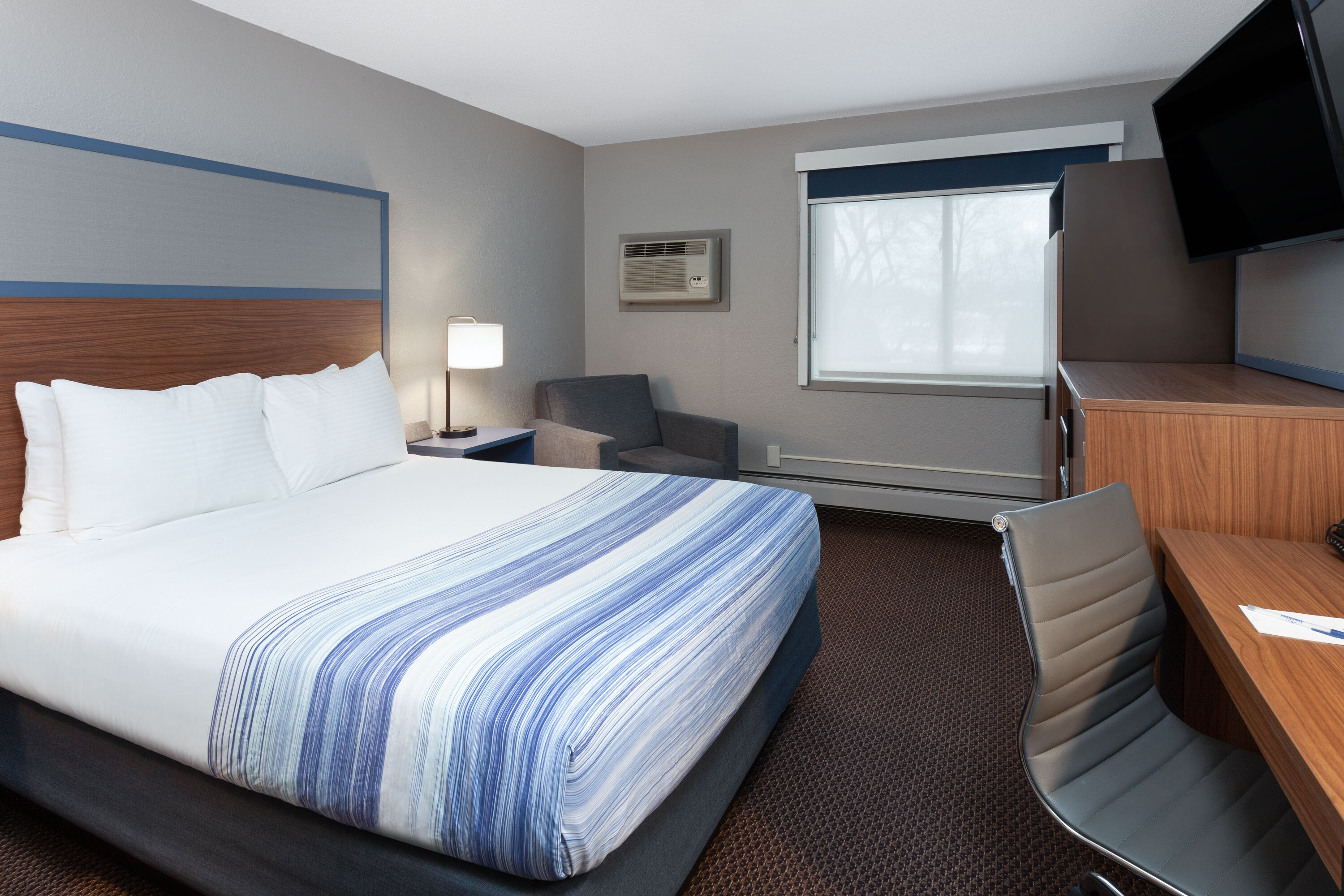 Queen bed guest room at the AmericInn by Wyndham New Richmond in New Richmond, Wisconsin