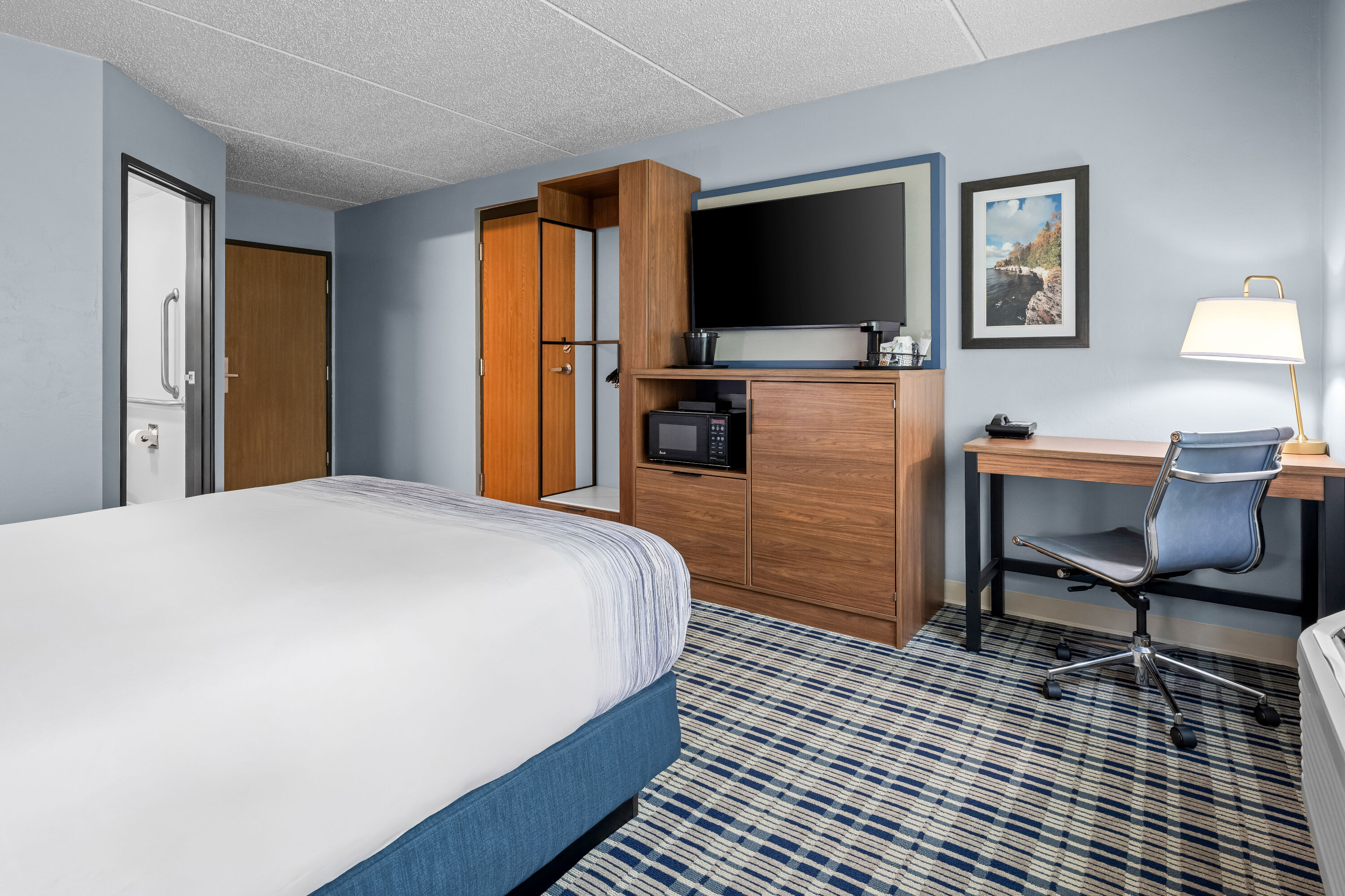 Queen bed guest room at the AmericInn by Wyndham Sturgeon Bay in Sturgeon Bay, Wisconsin