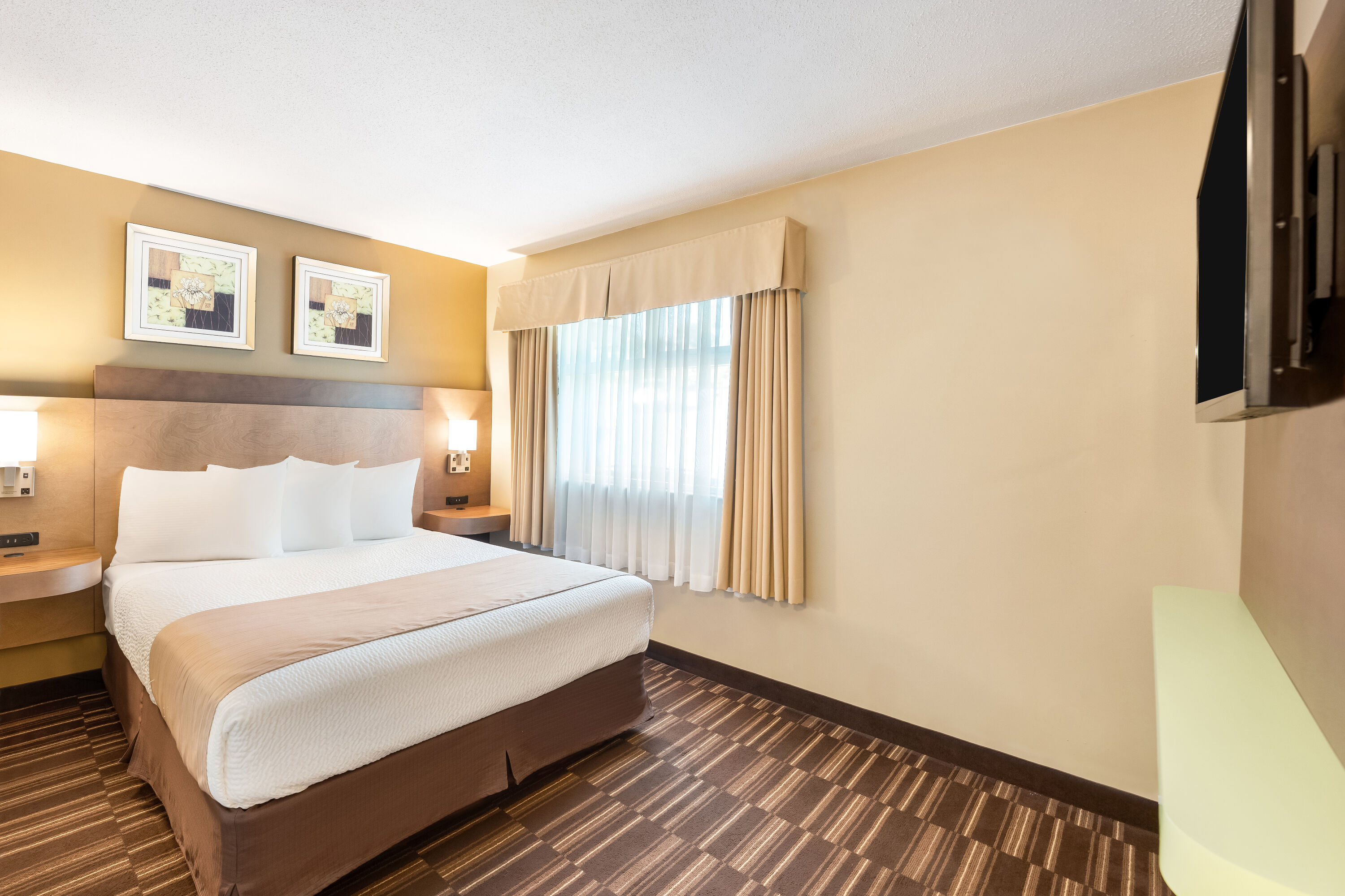 Queen bed guest room at the Days Inn by Wyndham Nanaimo in Nanaimo, British Columbia