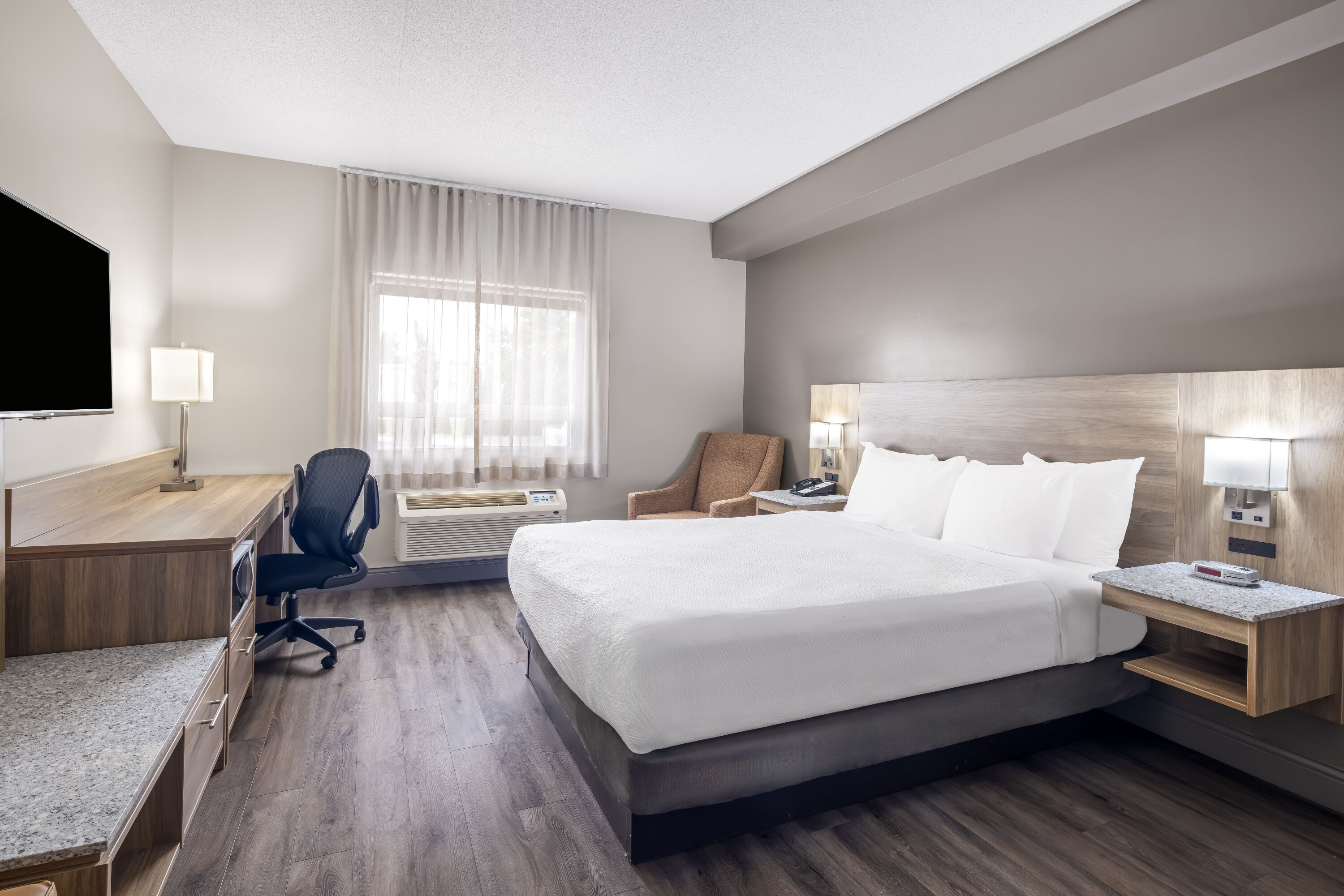 Queen bed guest room at the Days Inn by Wyndham Leamington in Leamington, Ontario