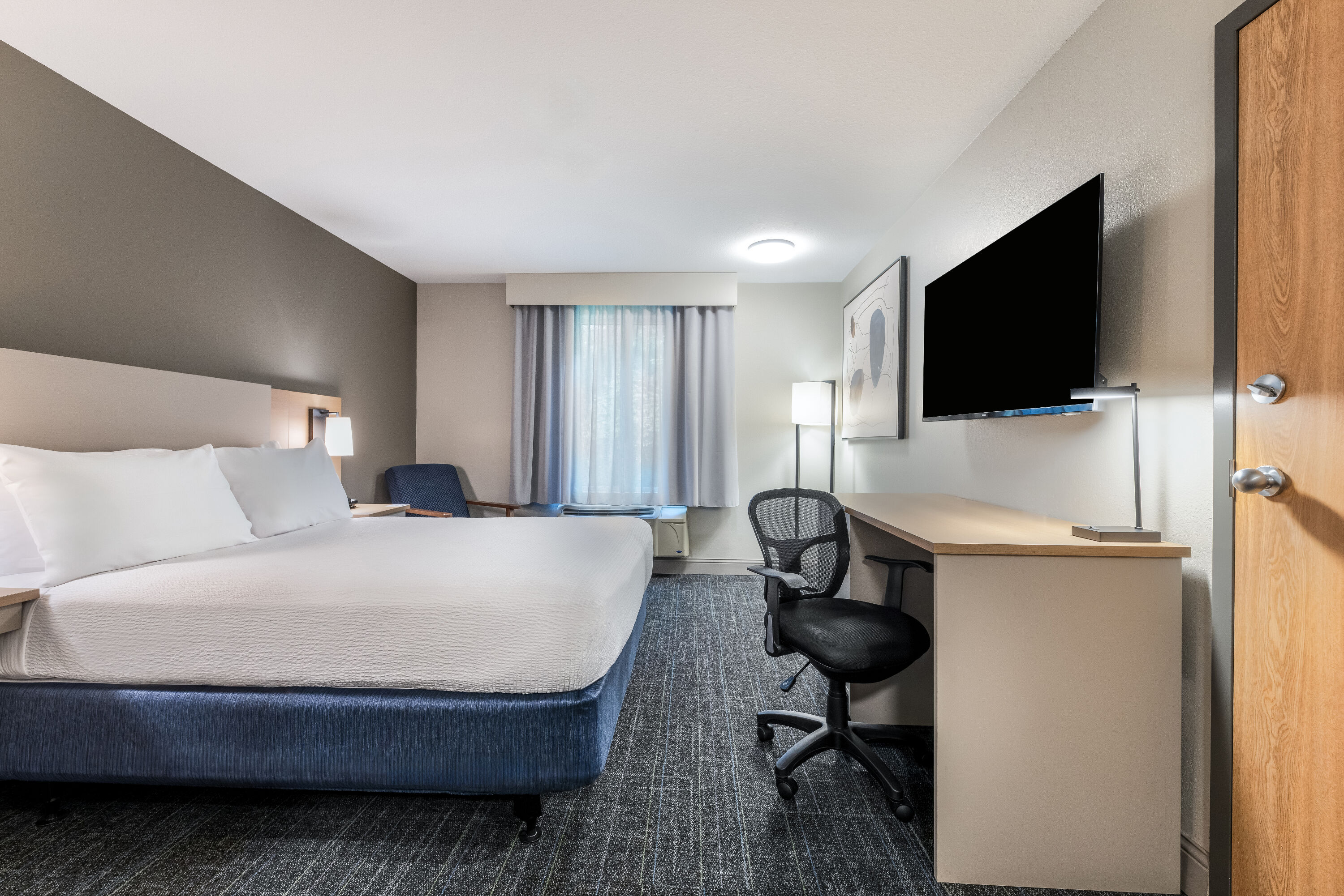 Queen bed guest room at the Days Inn & Suites by Wyndham Thunder Bay in Thunder Bay, Ontario