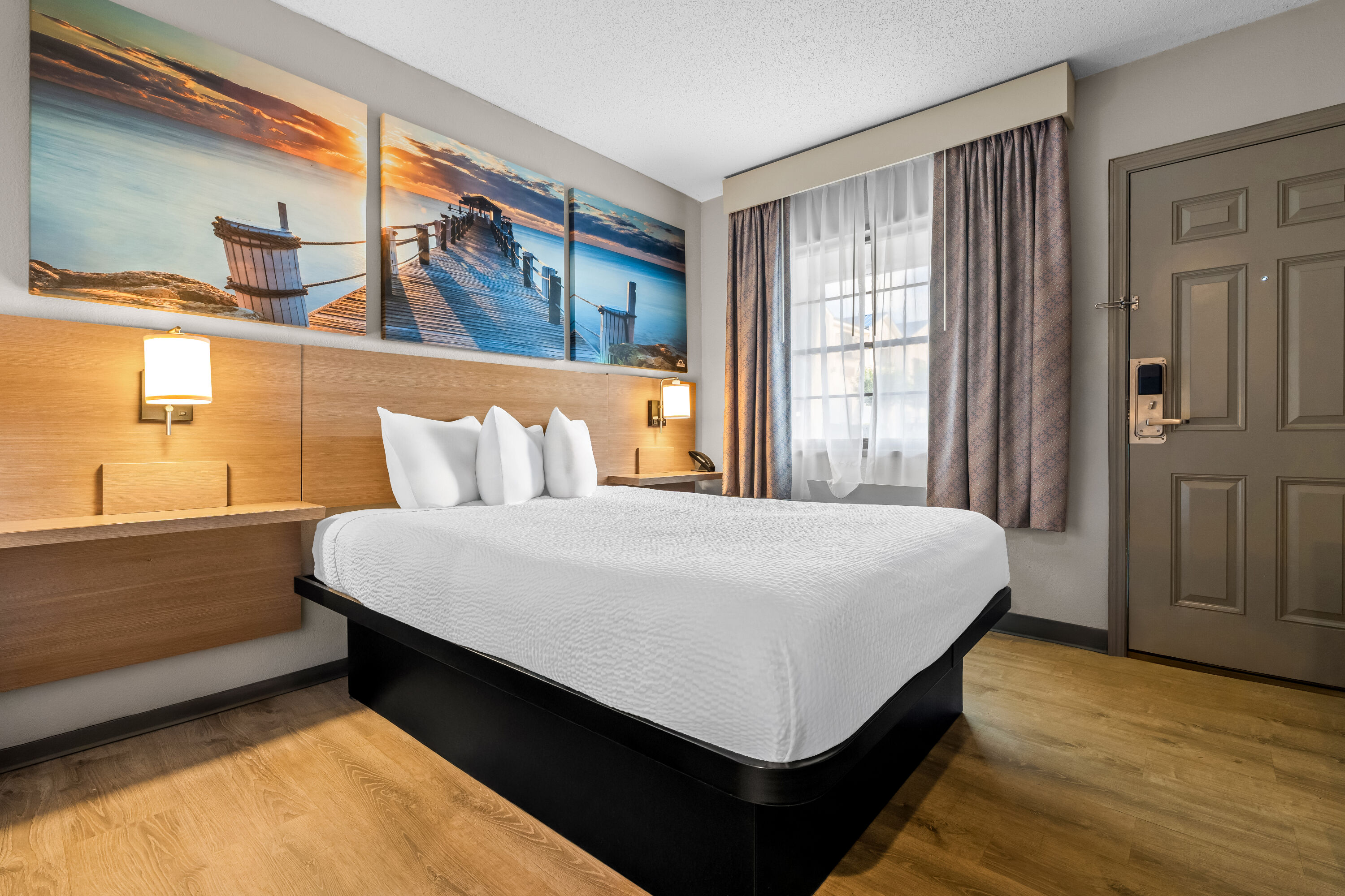 Queen bed guest room at the Days Inn by Wyndham Troy in Troy, Alabama