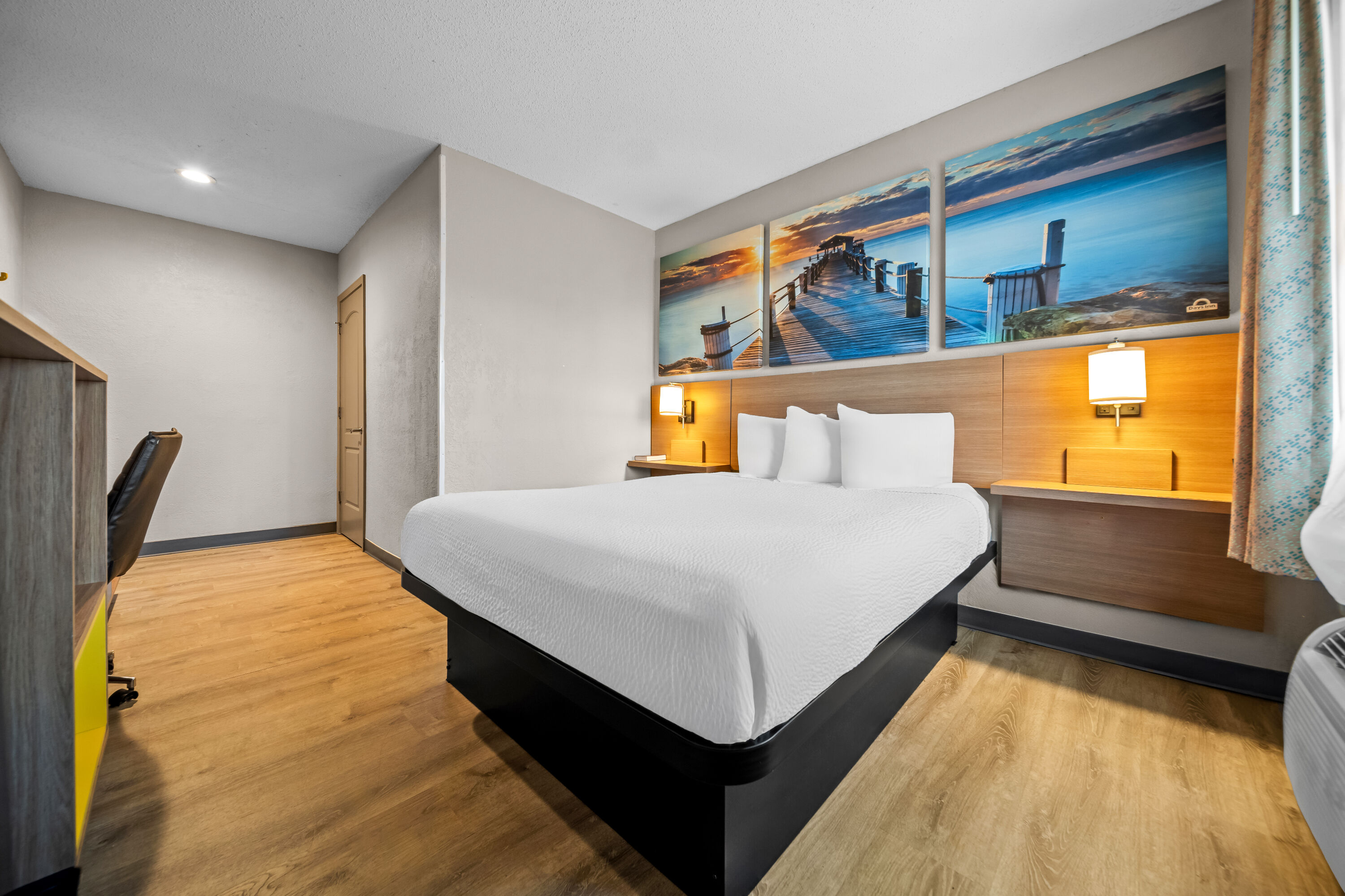 Queen bed guest room at the Days Inn by Wyndham Troy in Troy, Alabama