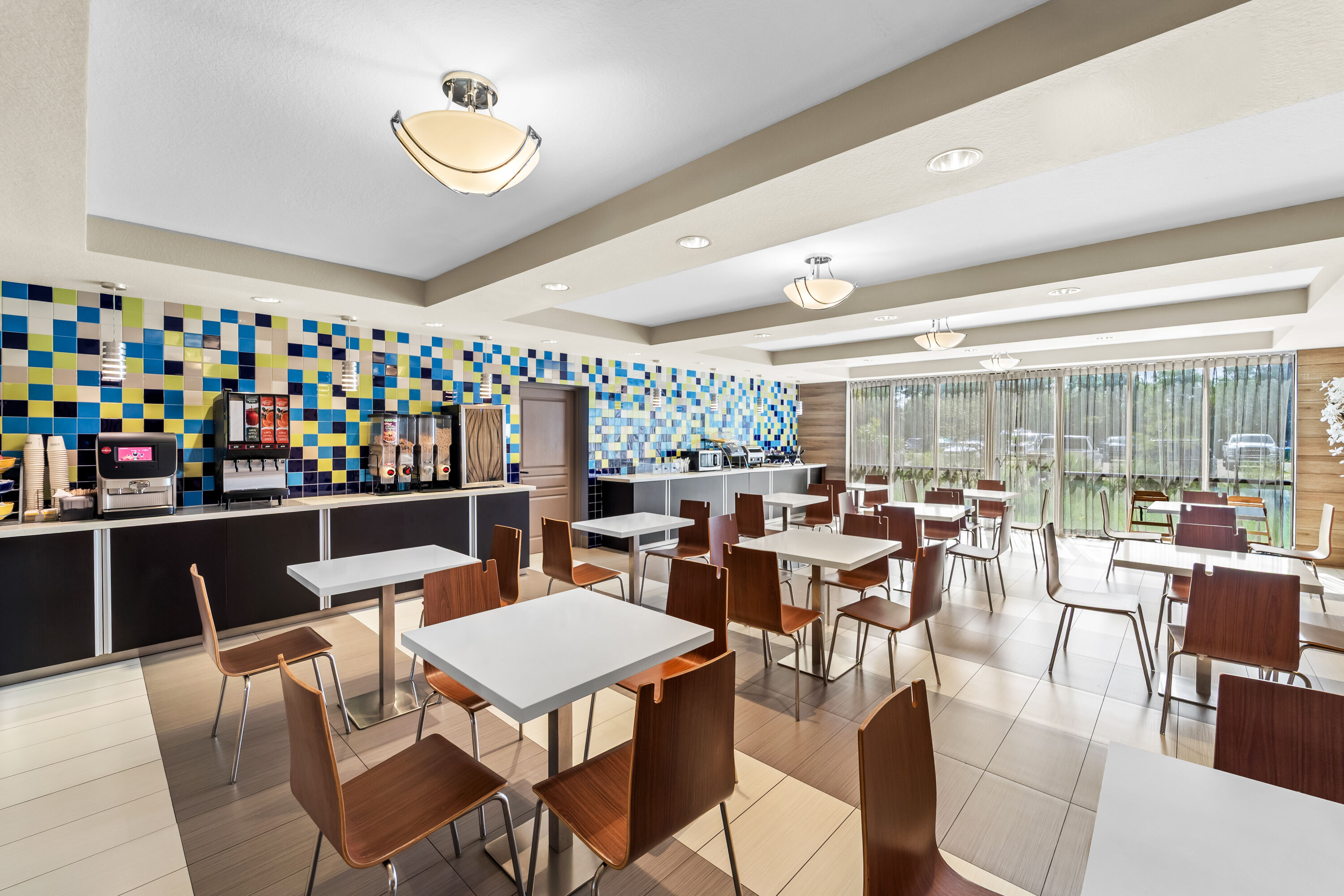 Days Inn & Suites by Wyndham Fort Myers Near JetBlue Park restaurant breakfast area with seating in Fort Myers, Florida