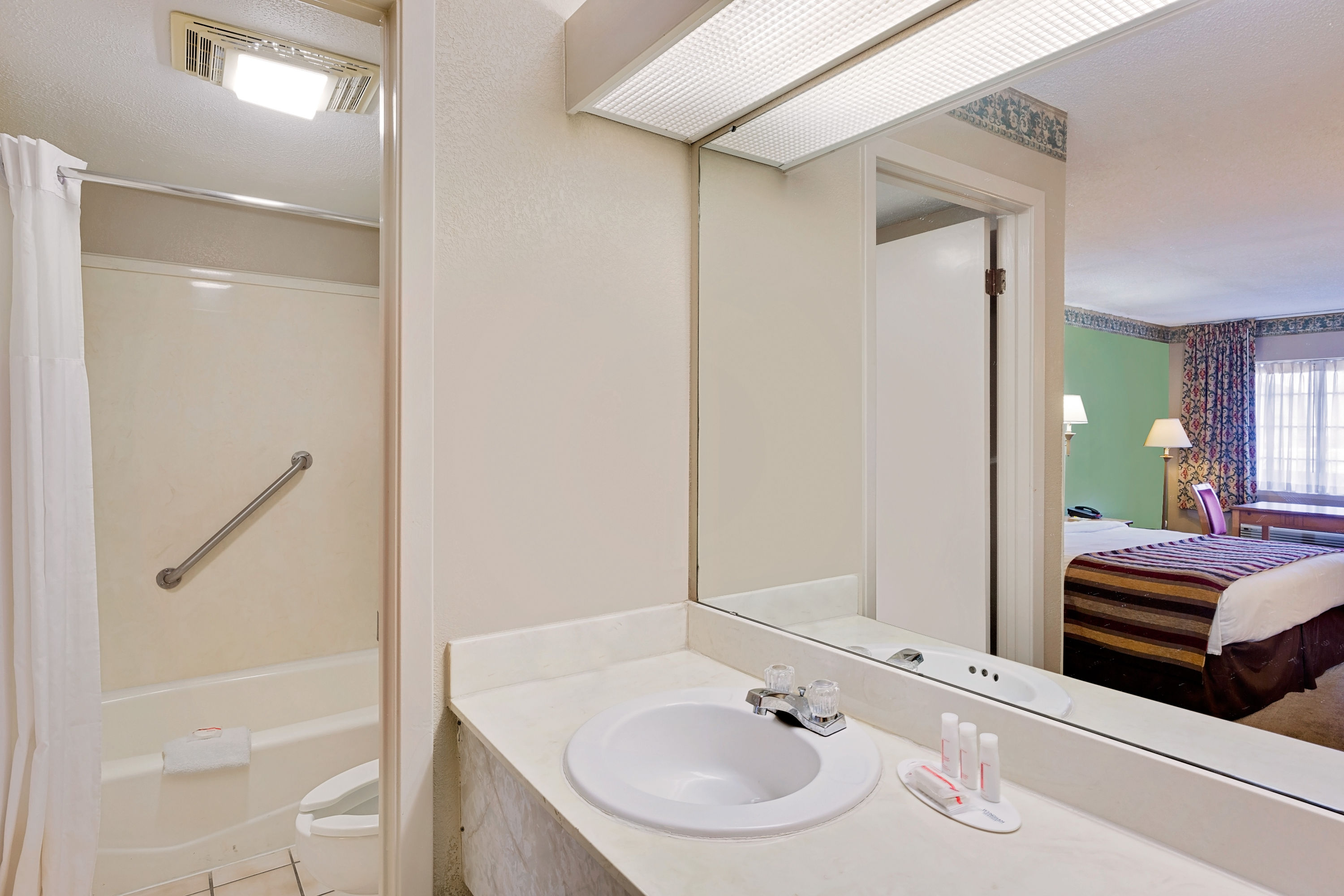 Guest room bath at the Days Inn & Suites by Wyndham Starkville in Starkville, Mississippi