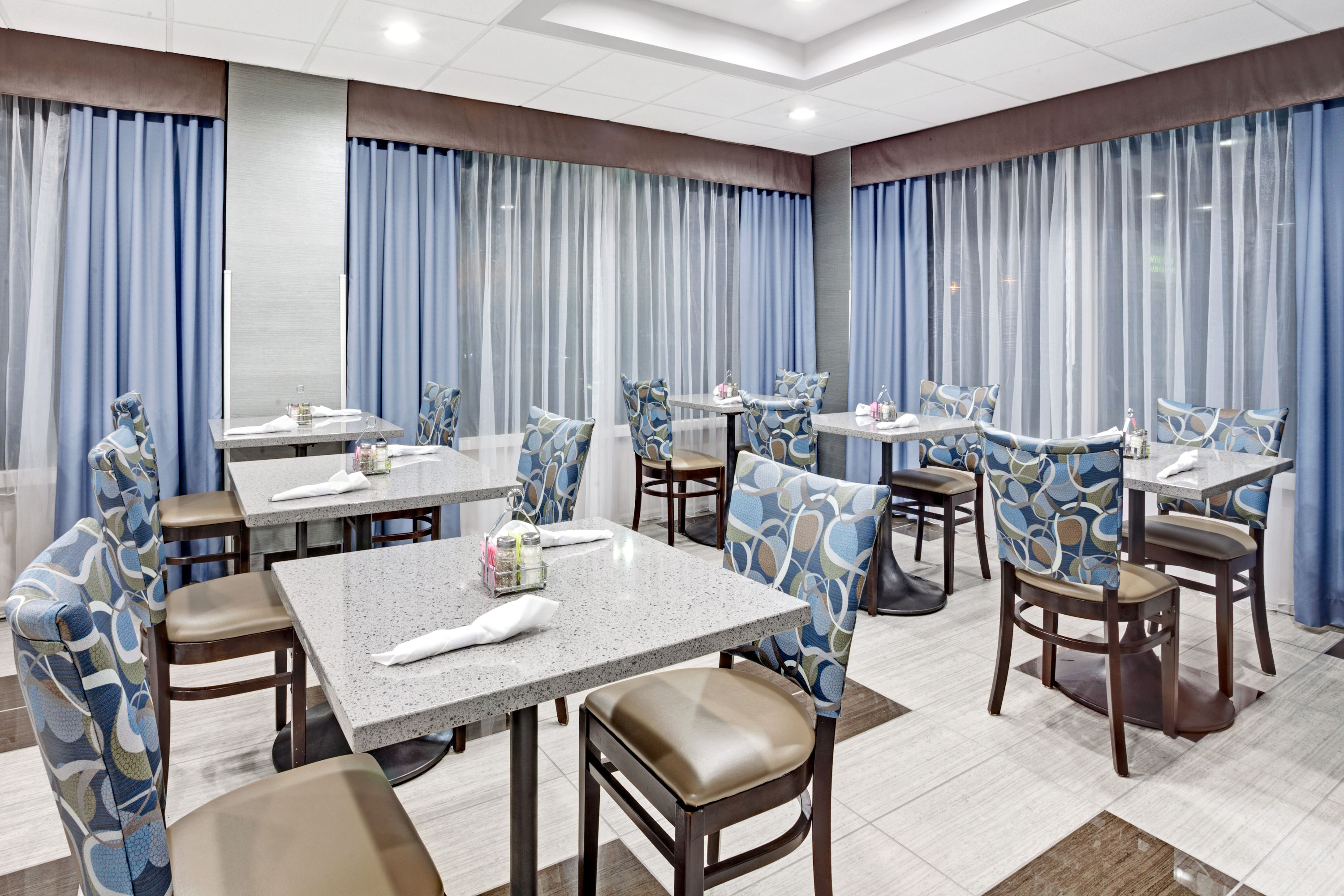 Dining room at Wyndham Garden Charlotte Airport Southeast with blue-patterned chairs and modern tables