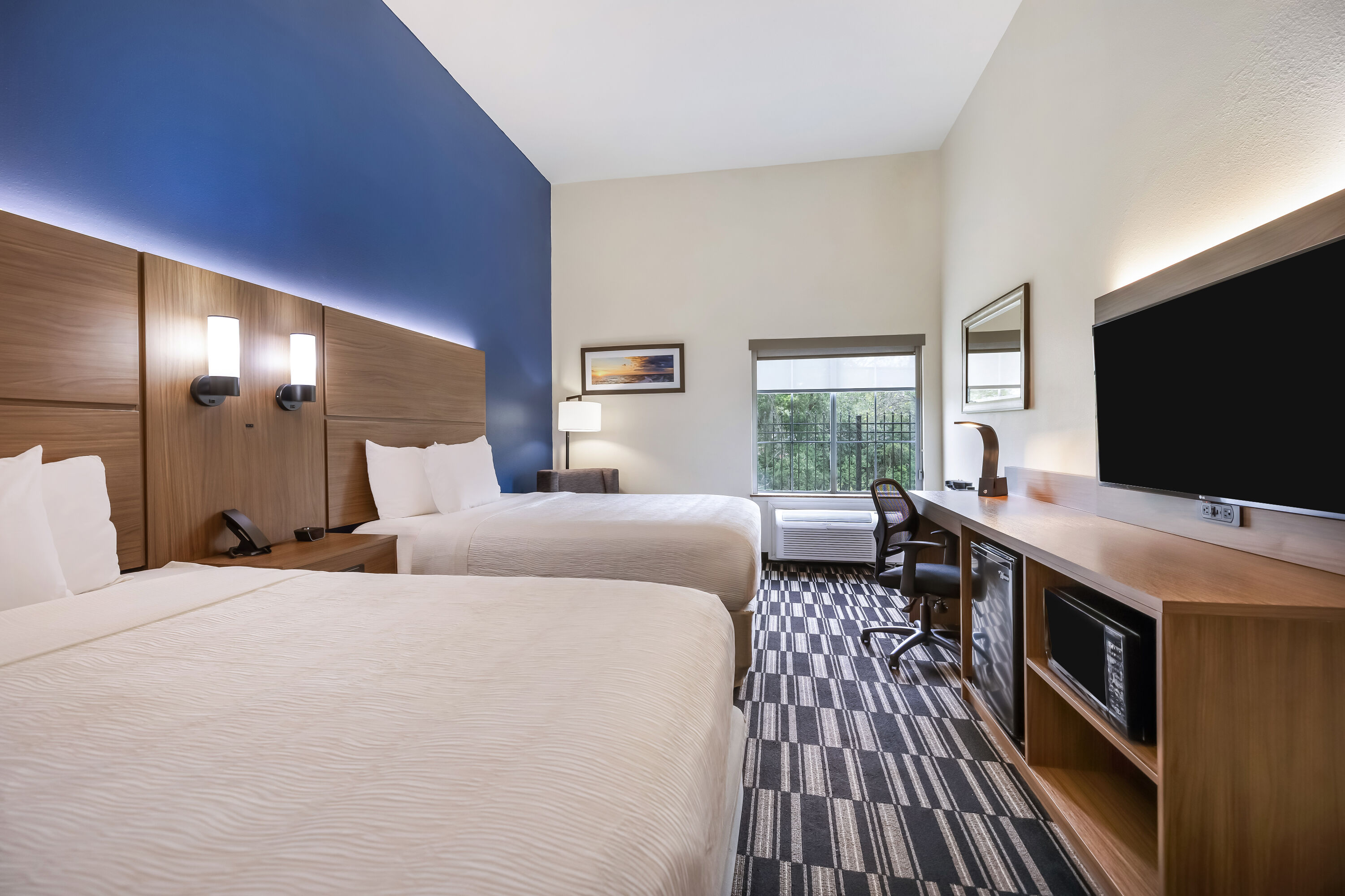 Queen bed guest room at the La Quinta Inn & Suites by Wyndham Alvin in Alvin, Texas