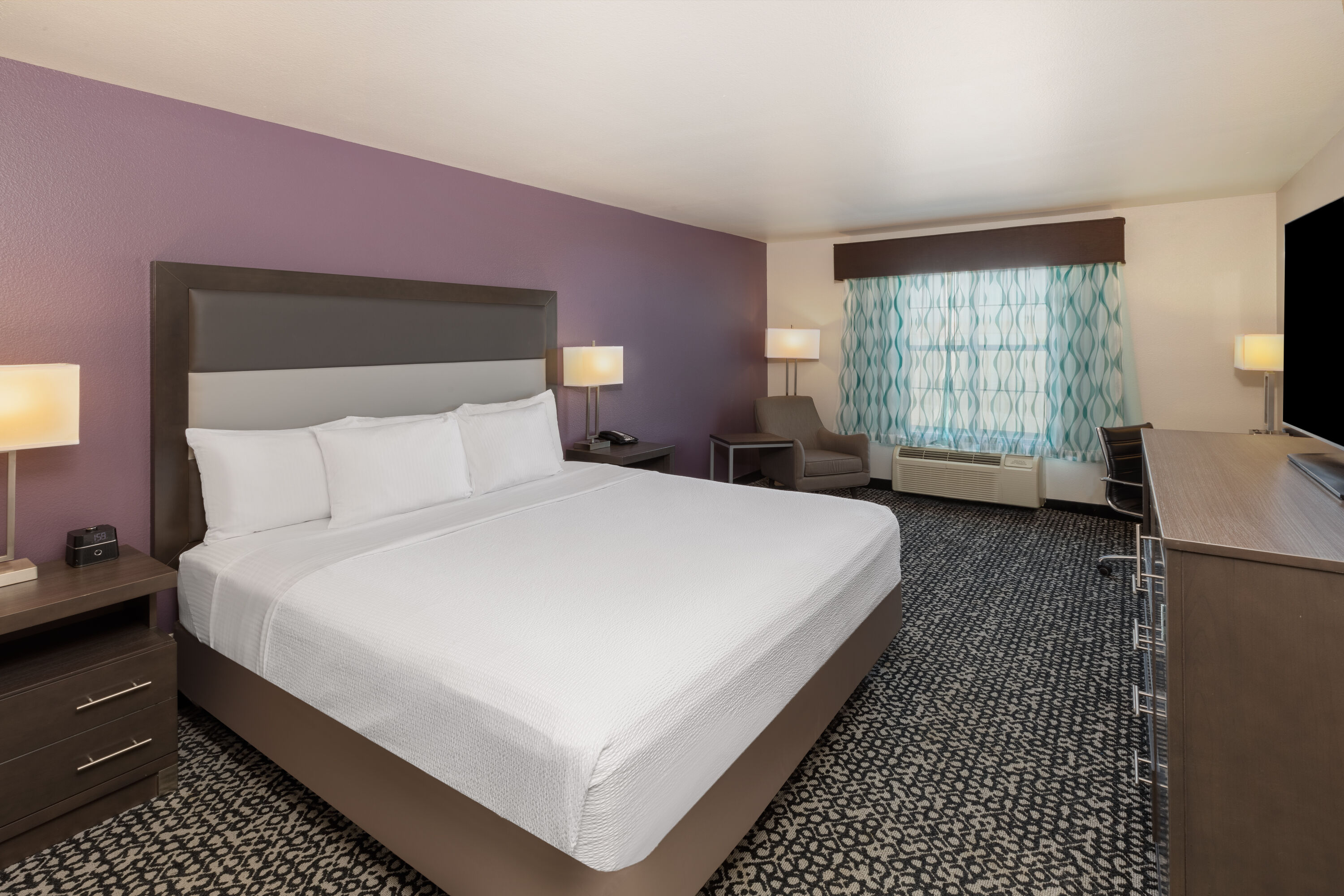 King bed guest room at the La Quinta Inn & Suites by Wyndham Rockwall in Rockwall, Texas