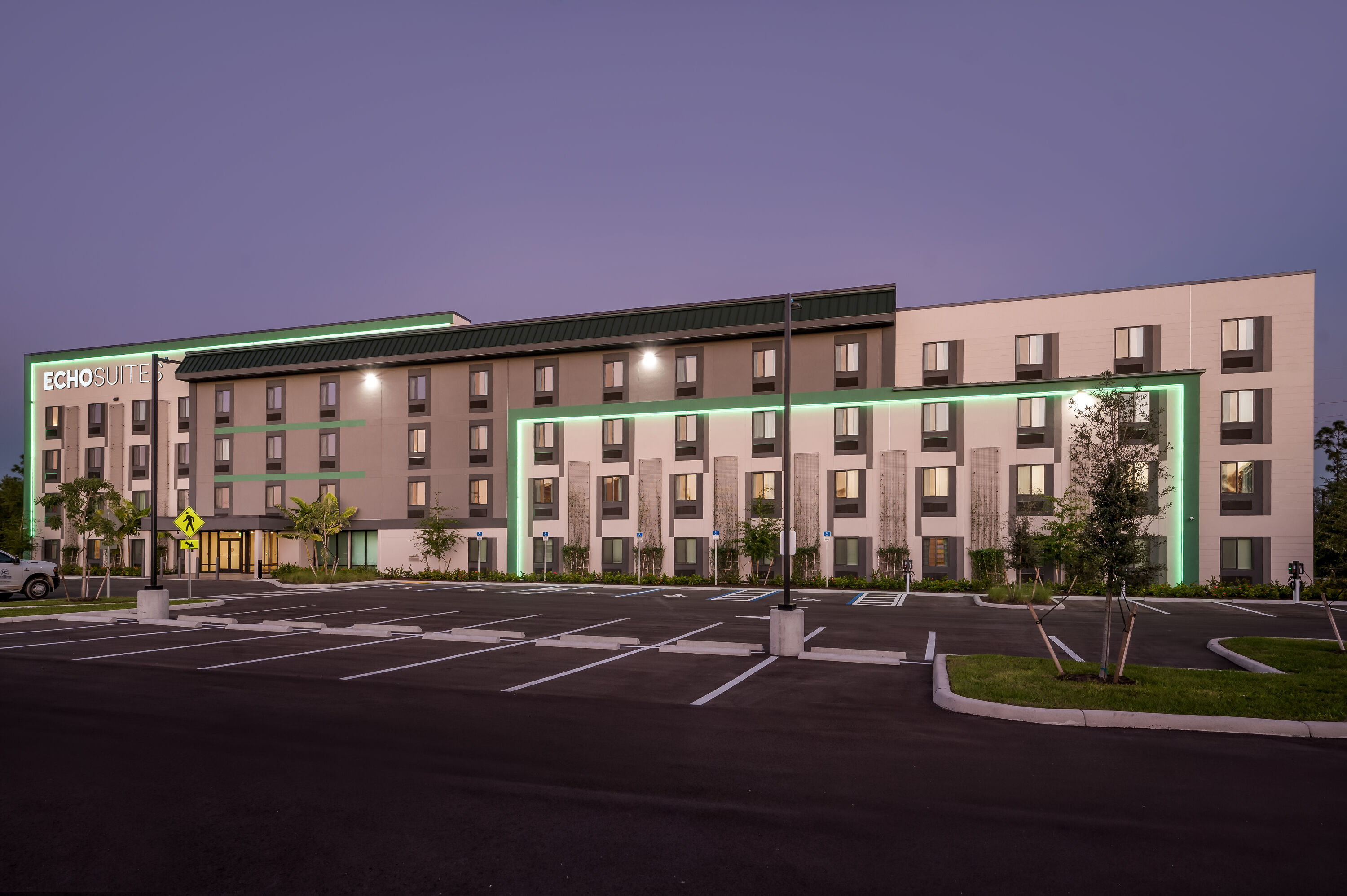 Exterior Night Image of ECHO Suites Extended Stay by Wyndham Naples hotel in Naples, Florida