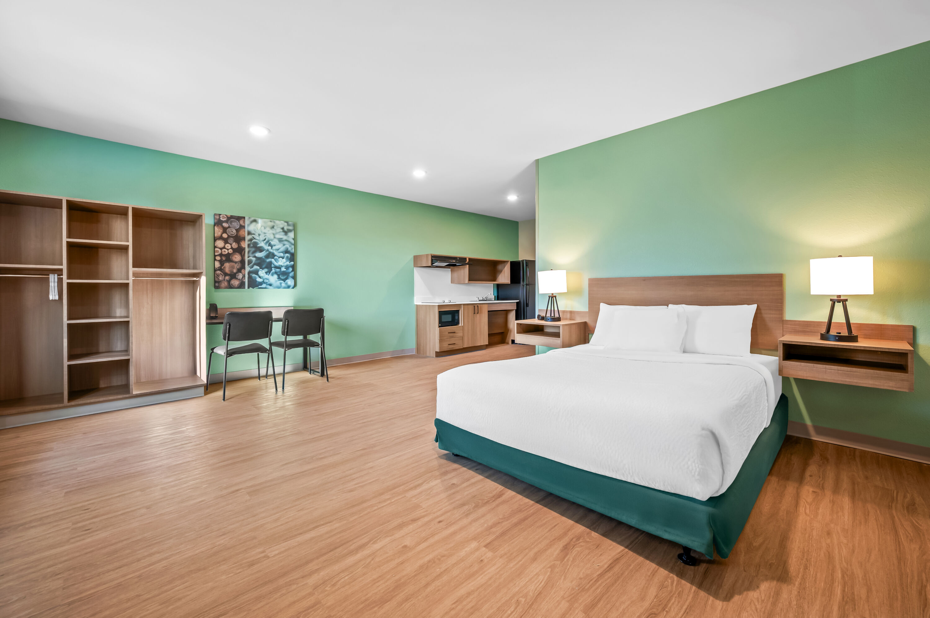 Queen bed guest room at the ECHO Suites Extended Stay by Wyndham Naples in Naples, Florida