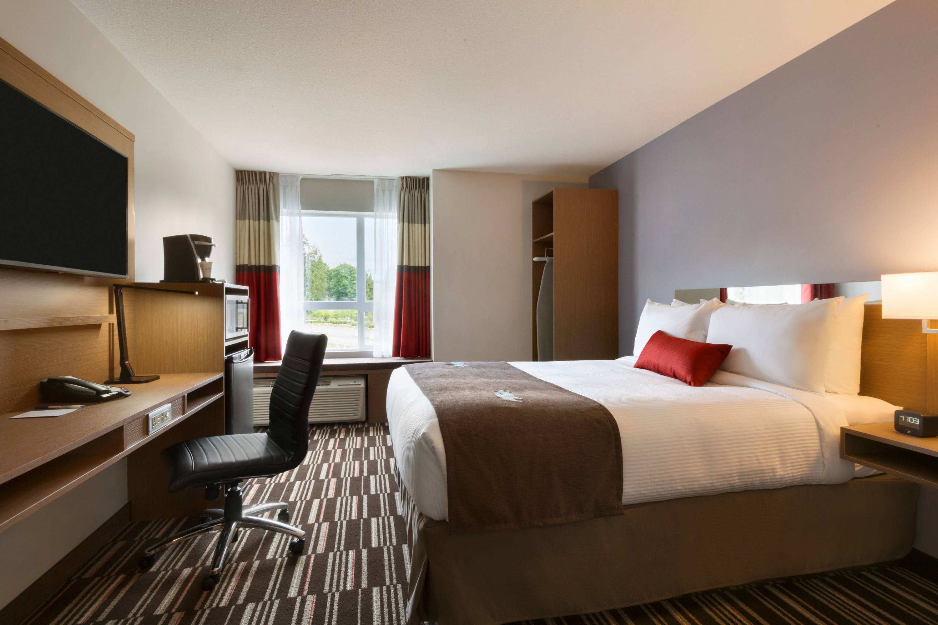 Queen bed guest room at the Microtel Inn & Suites by Wyndham Oyster Bay in Ladysmith, British Columbia