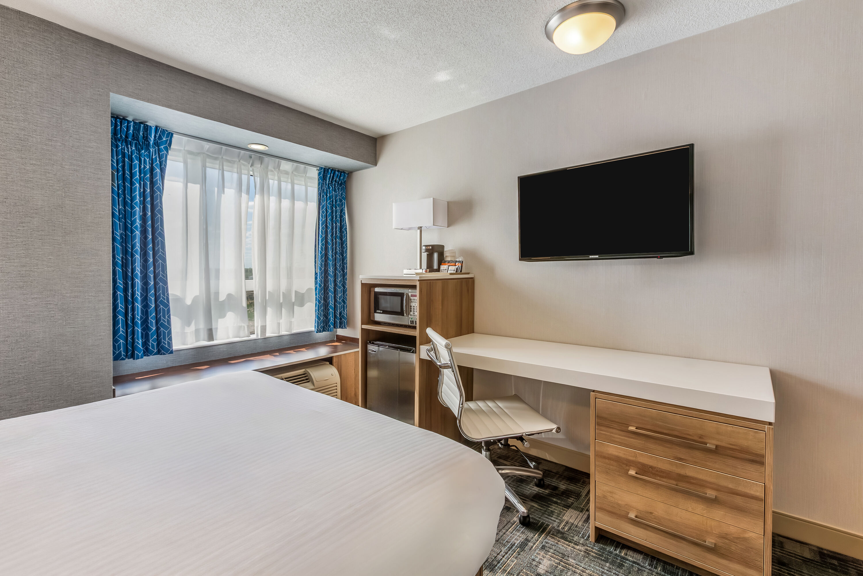 Queen bed guest room at the Microtel Inn & Suites by Wyndham Timmins in Timmins, Ontario