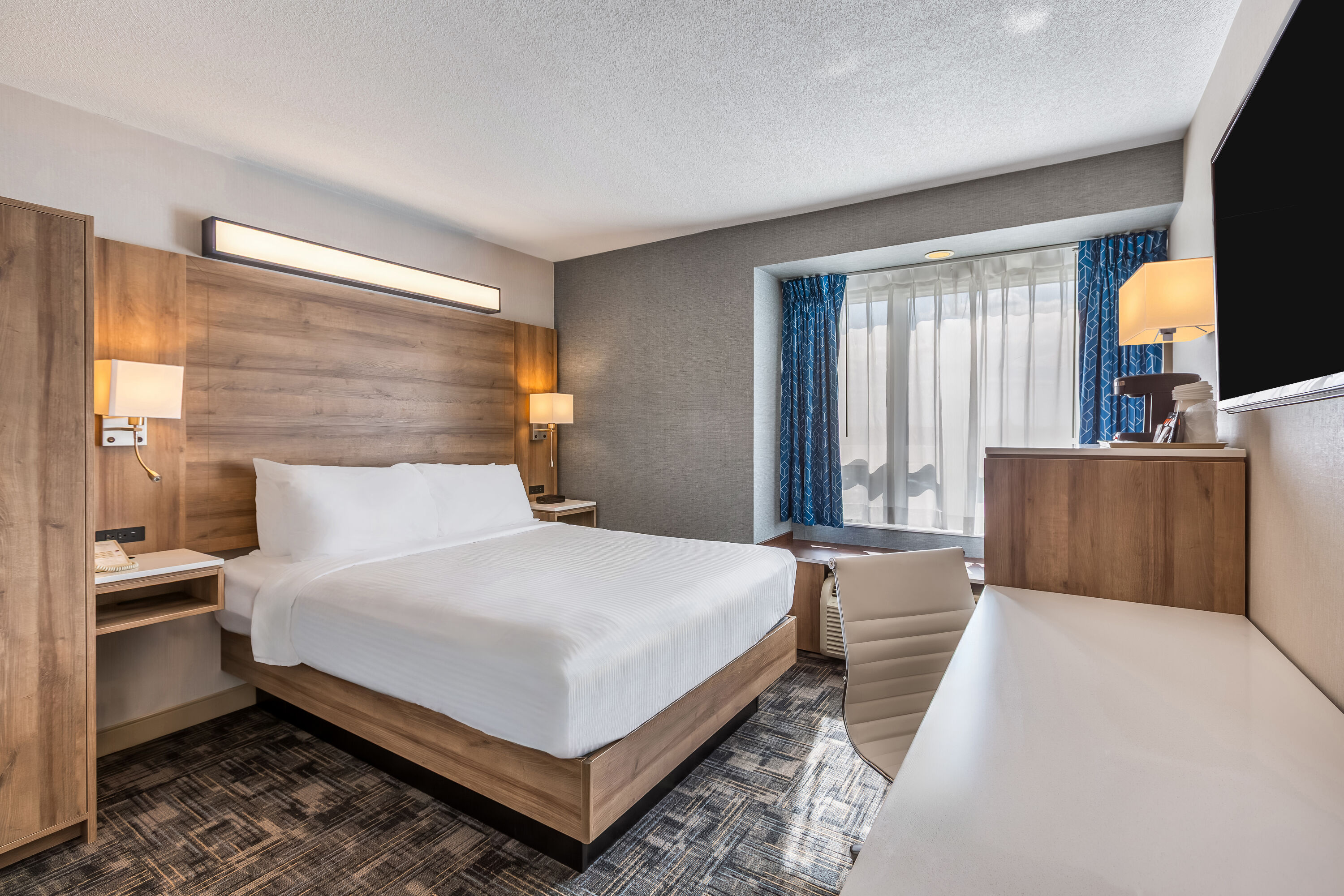 Queen bed guest room at the Microtel Inn & Suites by Wyndham Timmins in Timmins, Ontario