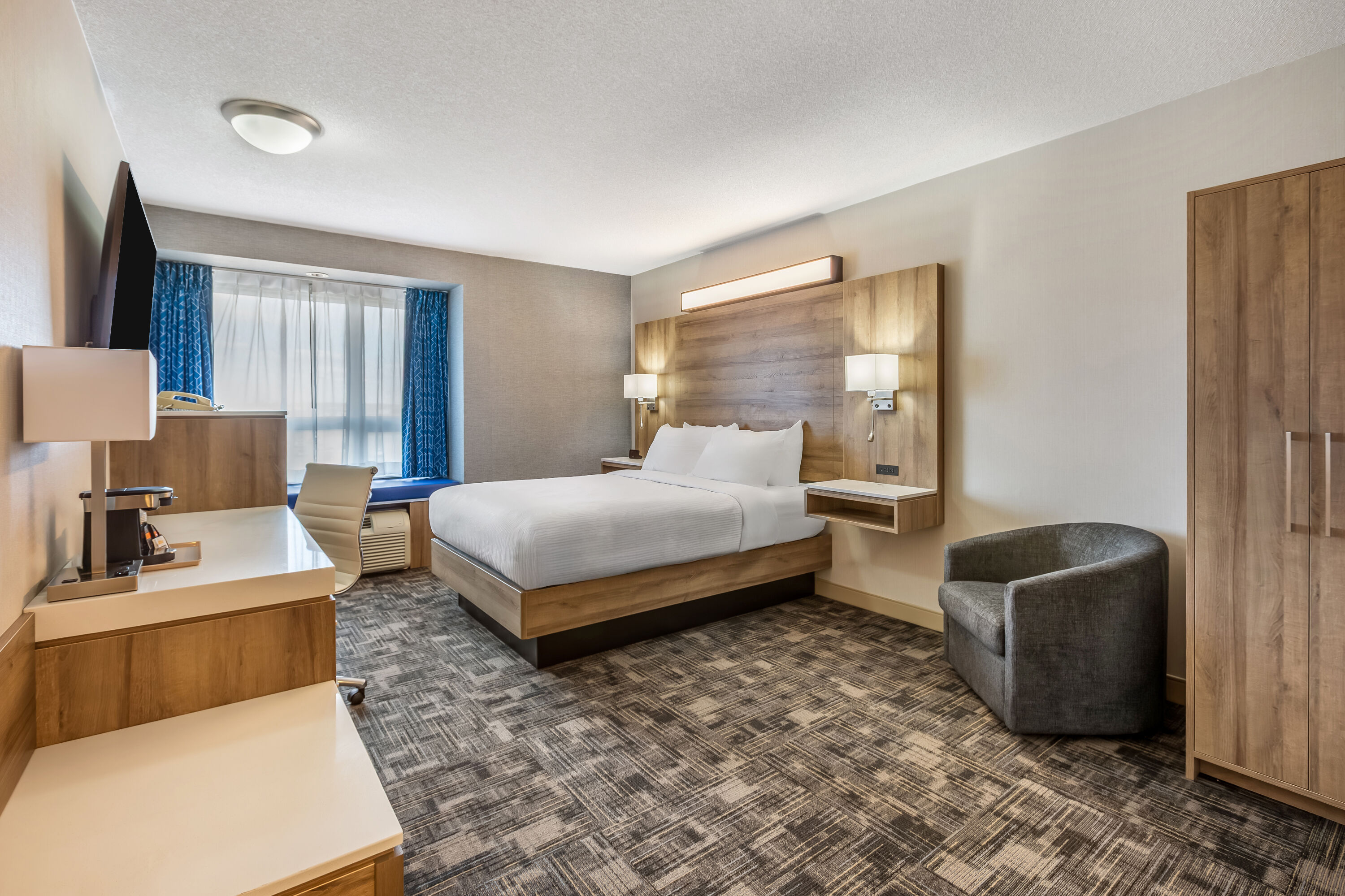 Queen bed guest room at the Microtel Inn & Suites by Wyndham Timmins in Timmins, Ontario