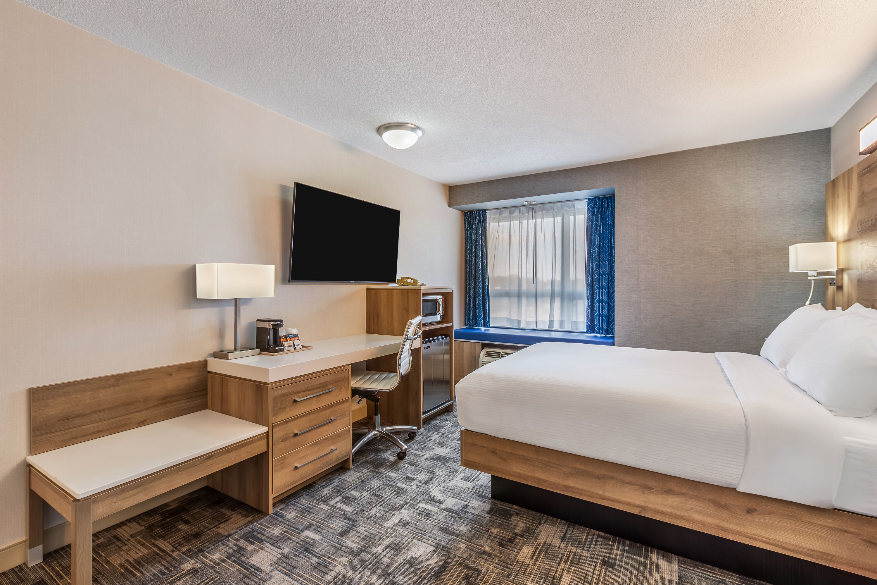 Queen bed guest room at the Microtel Inn & Suites by Wyndham Timmins in Timmins, Ontario