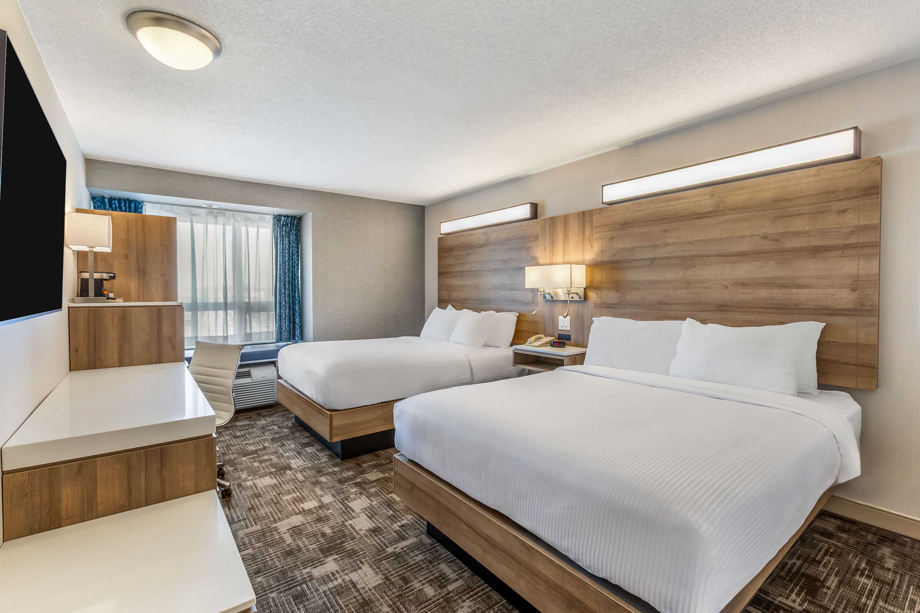 Queen bed guest room at the Microtel Inn & Suites by Wyndham Timmins in Timmins, Ontario