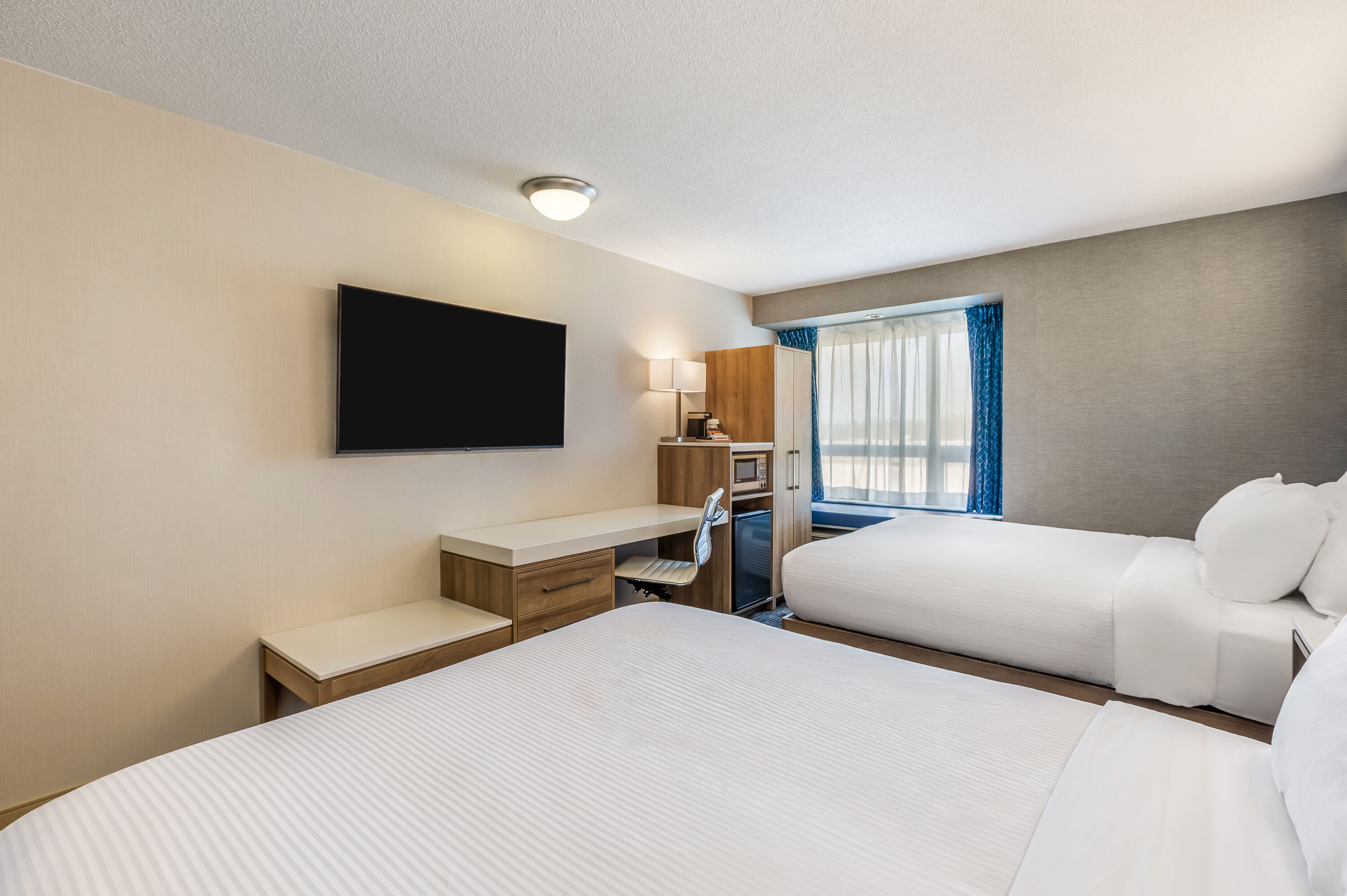 Queen bed guest room at the Microtel Inn & Suites by Wyndham Timmins in Timmins, Ontario