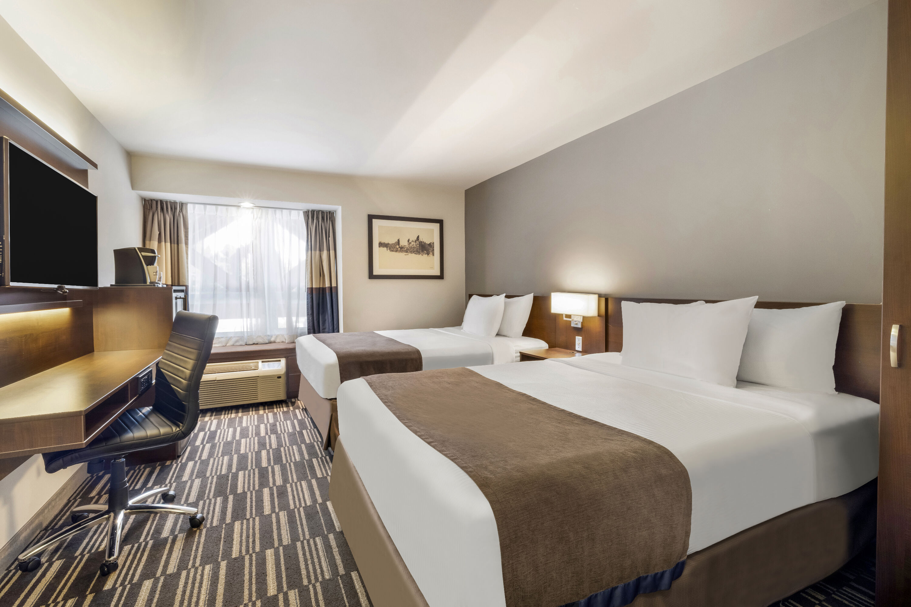 Queen bed guest room at the Microtel Inn & Suites by Wyndham Mont Tremblant in Mont-Tremblant, Quebec