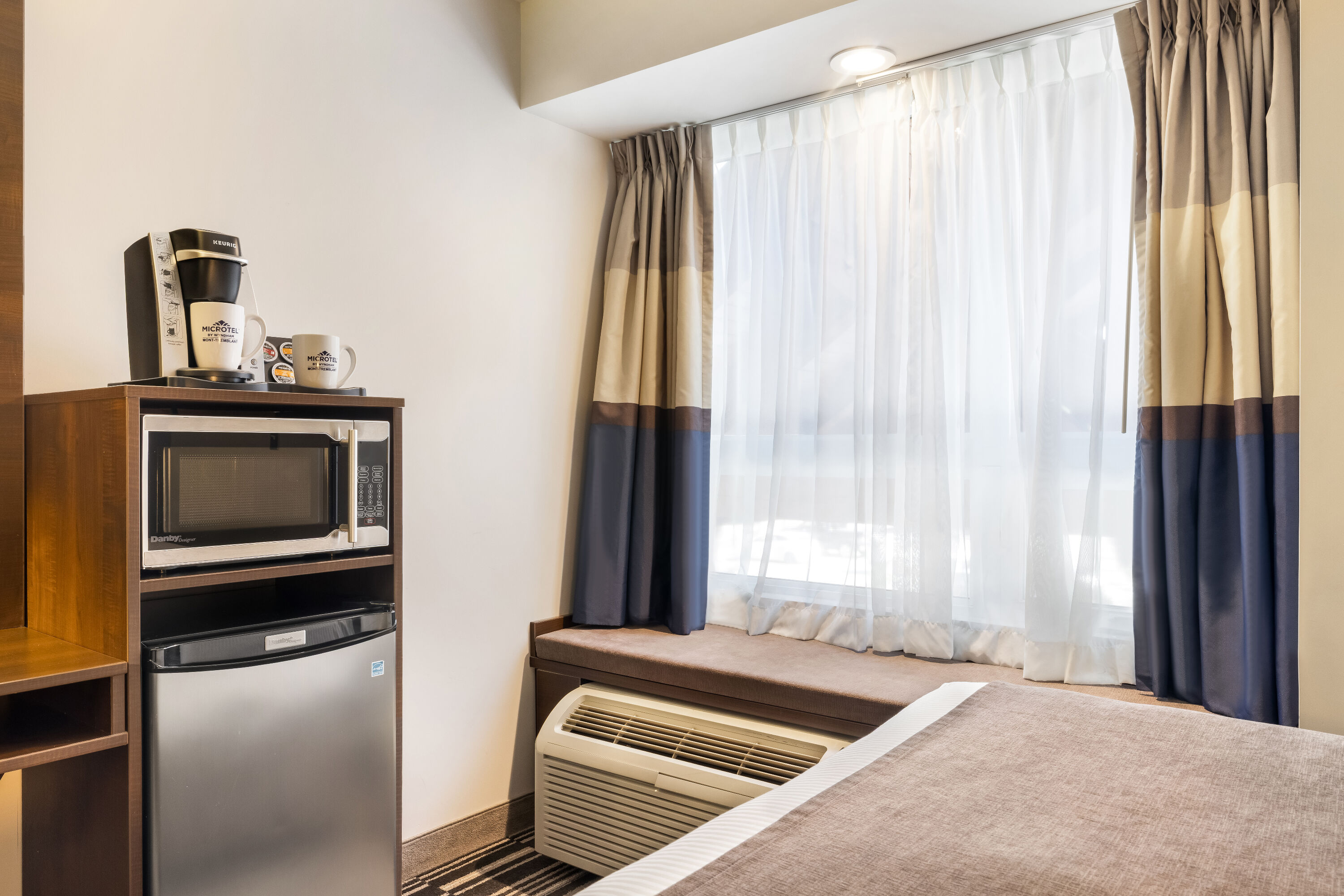 Queen bed guest room at the Microtel Inn & Suites by Wyndham Mont Tremblant in Mont-Tremblant, Quebec