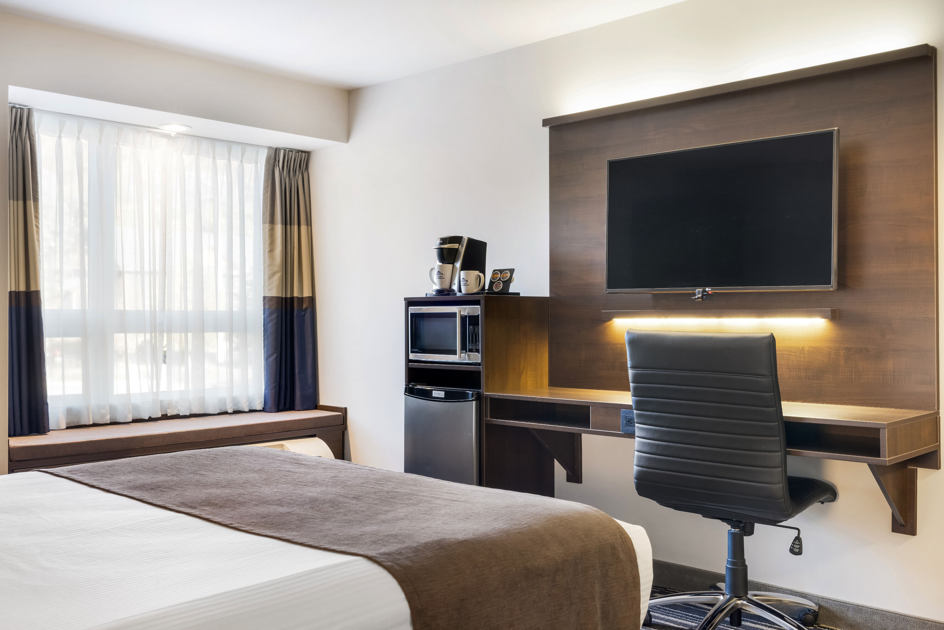 Queen bed guest room at the Microtel Inn & Suites by Wyndham Mont Tremblant in Mont-Tremblant, Quebec