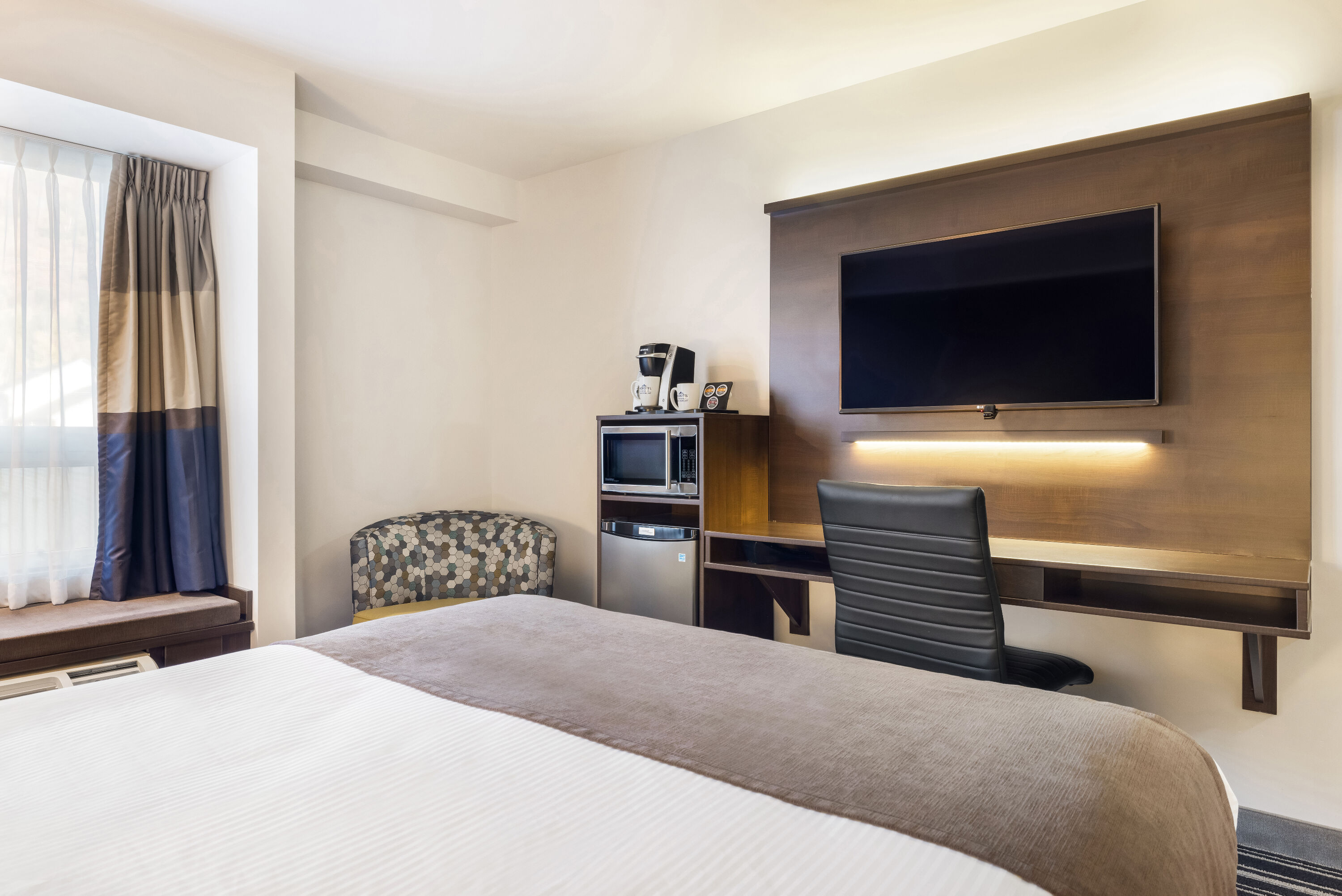 Queen bed guest room at the Microtel Inn & Suites by Wyndham Mont Tremblant in Mont-Tremblant, Quebec