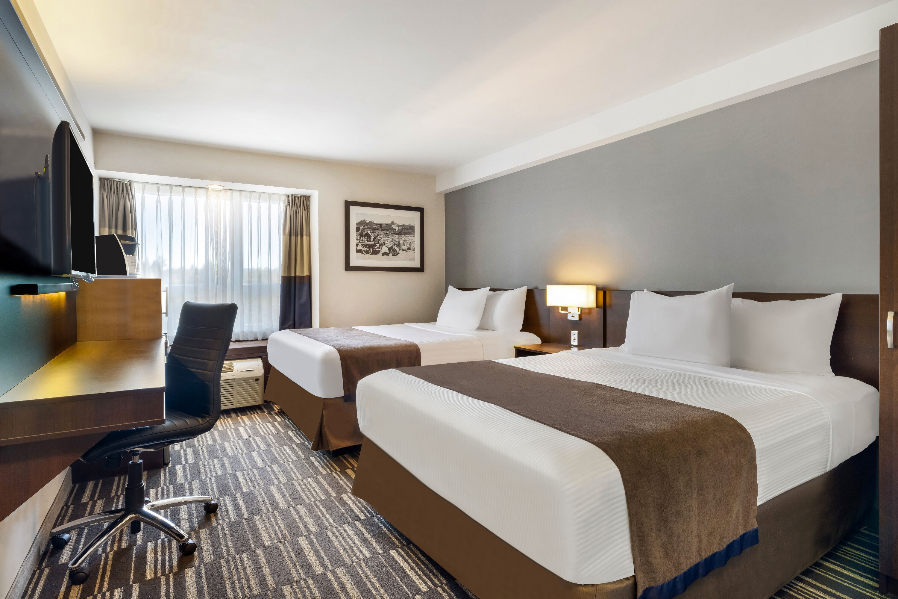 Queen bed guest room at the Microtel Inn & Suites by Wyndham Mont Tremblant in Mont-Tremblant, Quebec