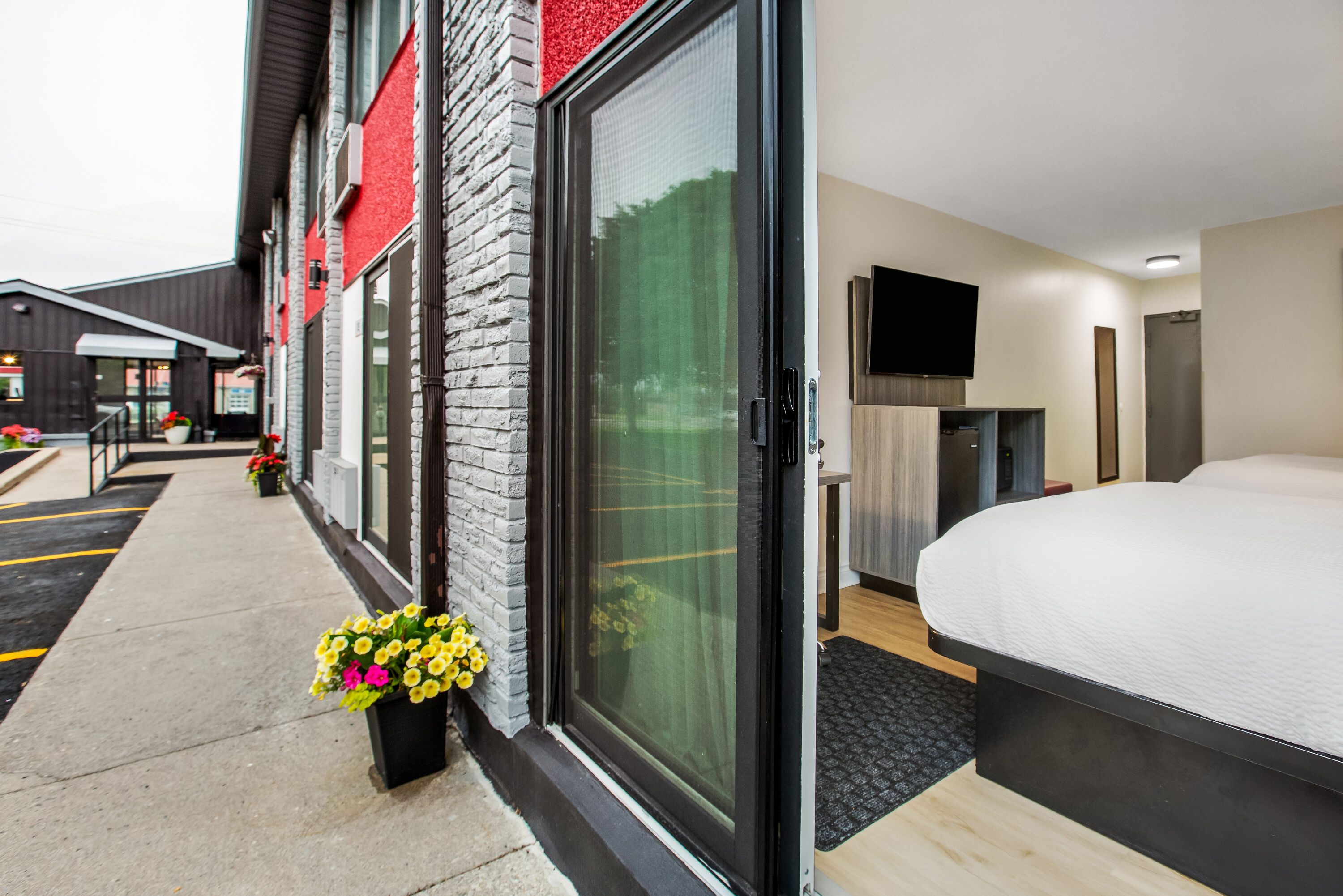 Queen bed guest room at the Ramada by Wyndham Kingston in Kingston, Ontario