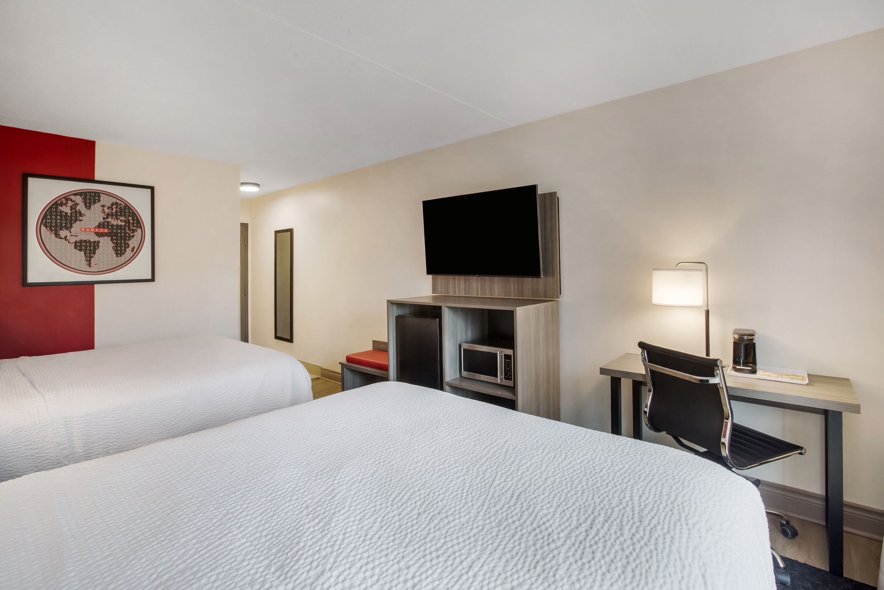 Queen bed guest room at the Ramada by Wyndham Kingston in Kingston, Ontario