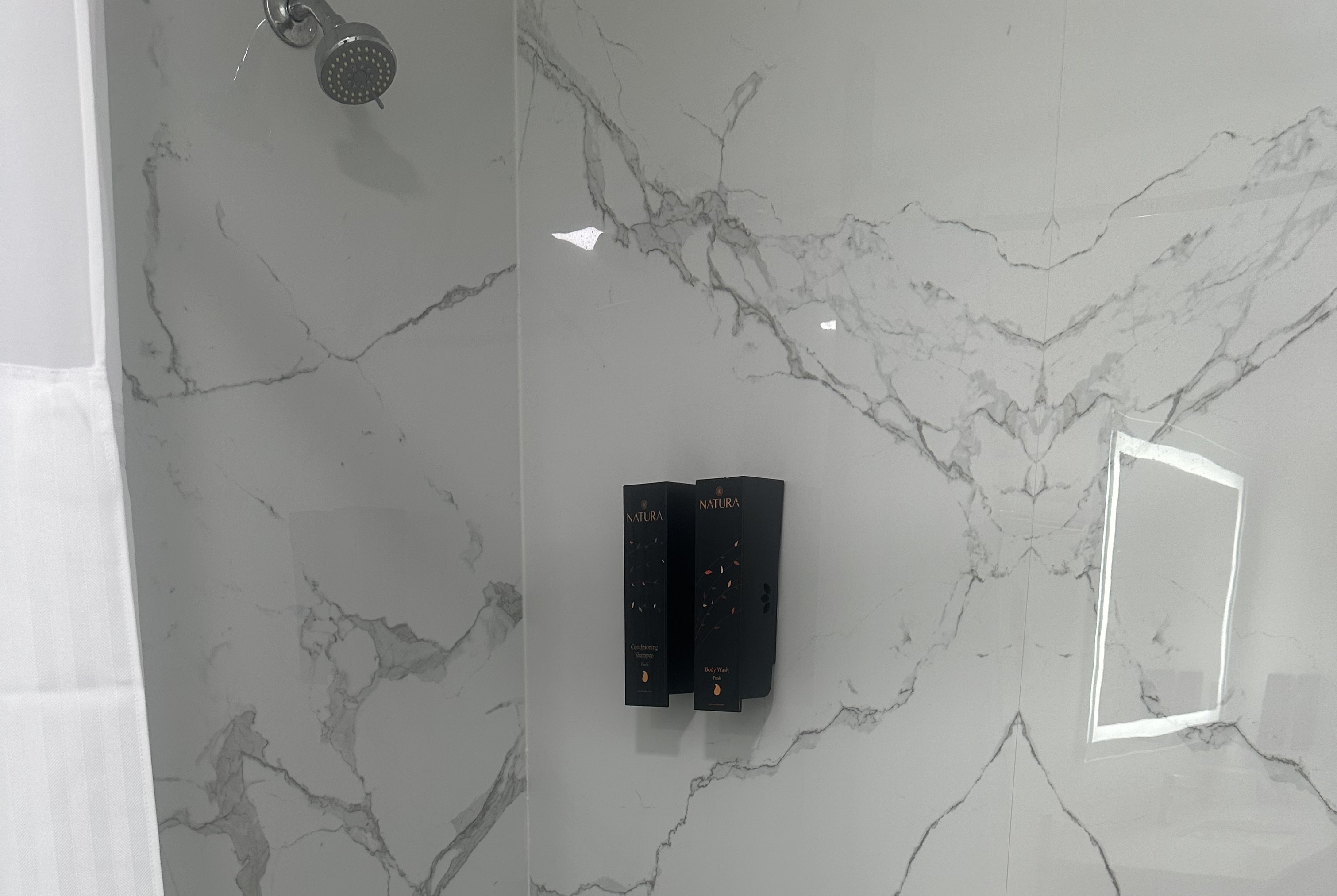 Guest room bath at the Super 8 by Wyndham Oceanside Downtown in Oceanside, California