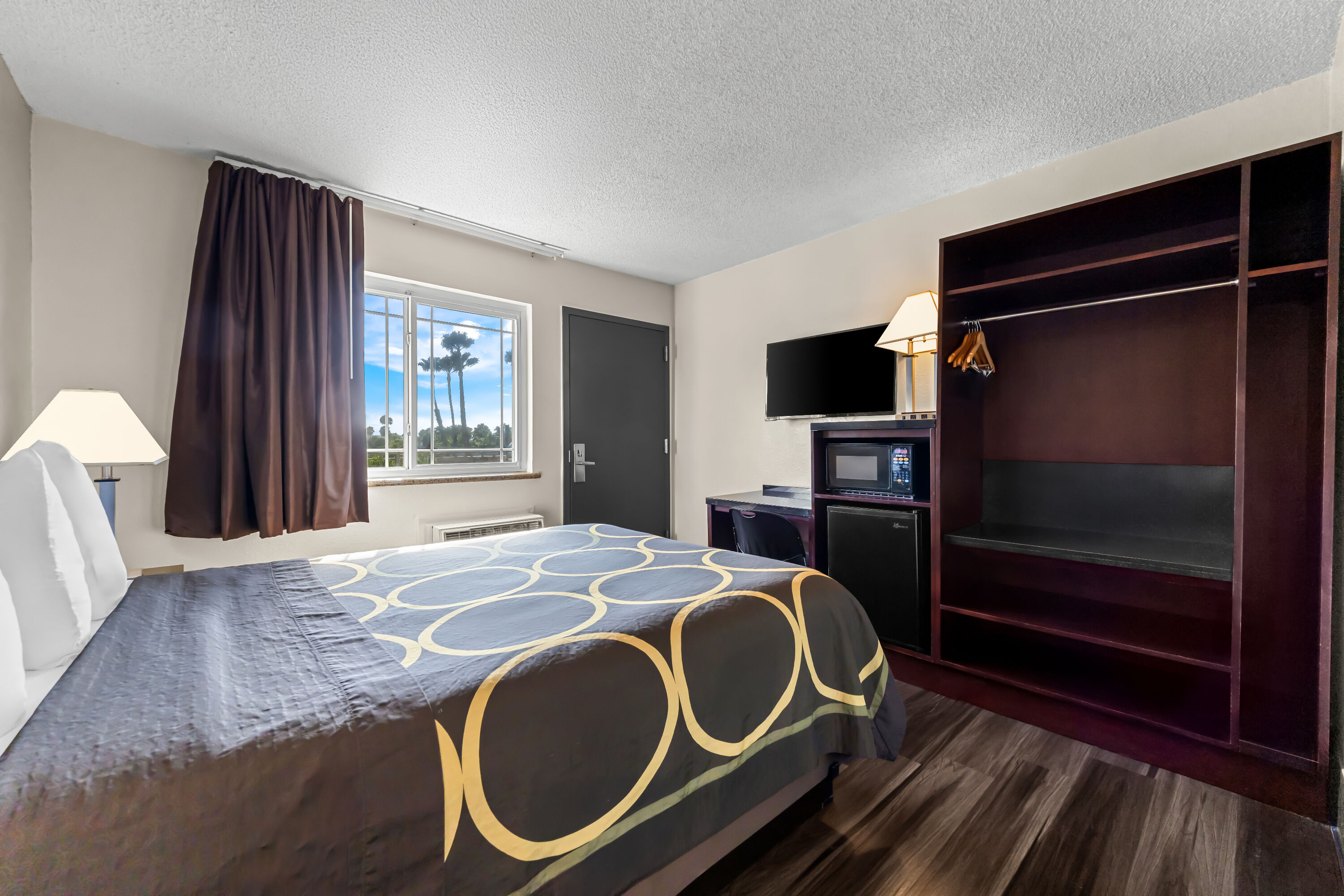 Queen bed guest room at the Super 8 by Wyndham San Diego Hotel Circle in San Diego, California