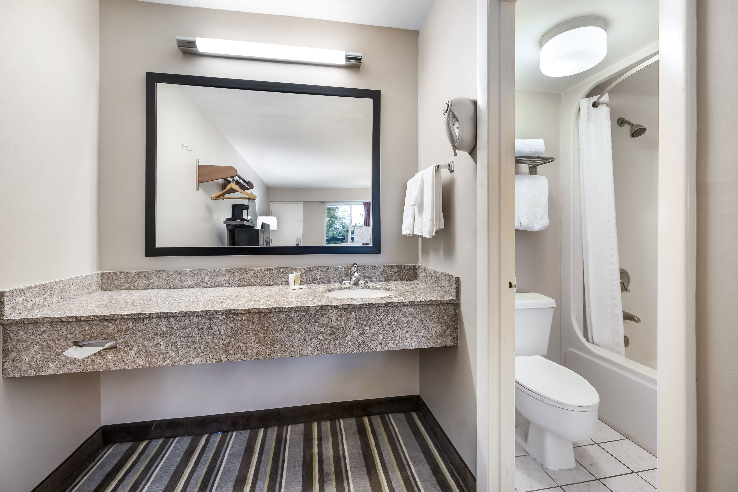 Guest room bath at the Super 8 by Wyndham Riviera Beach West Palm Beach in Riviera Beach, Florida