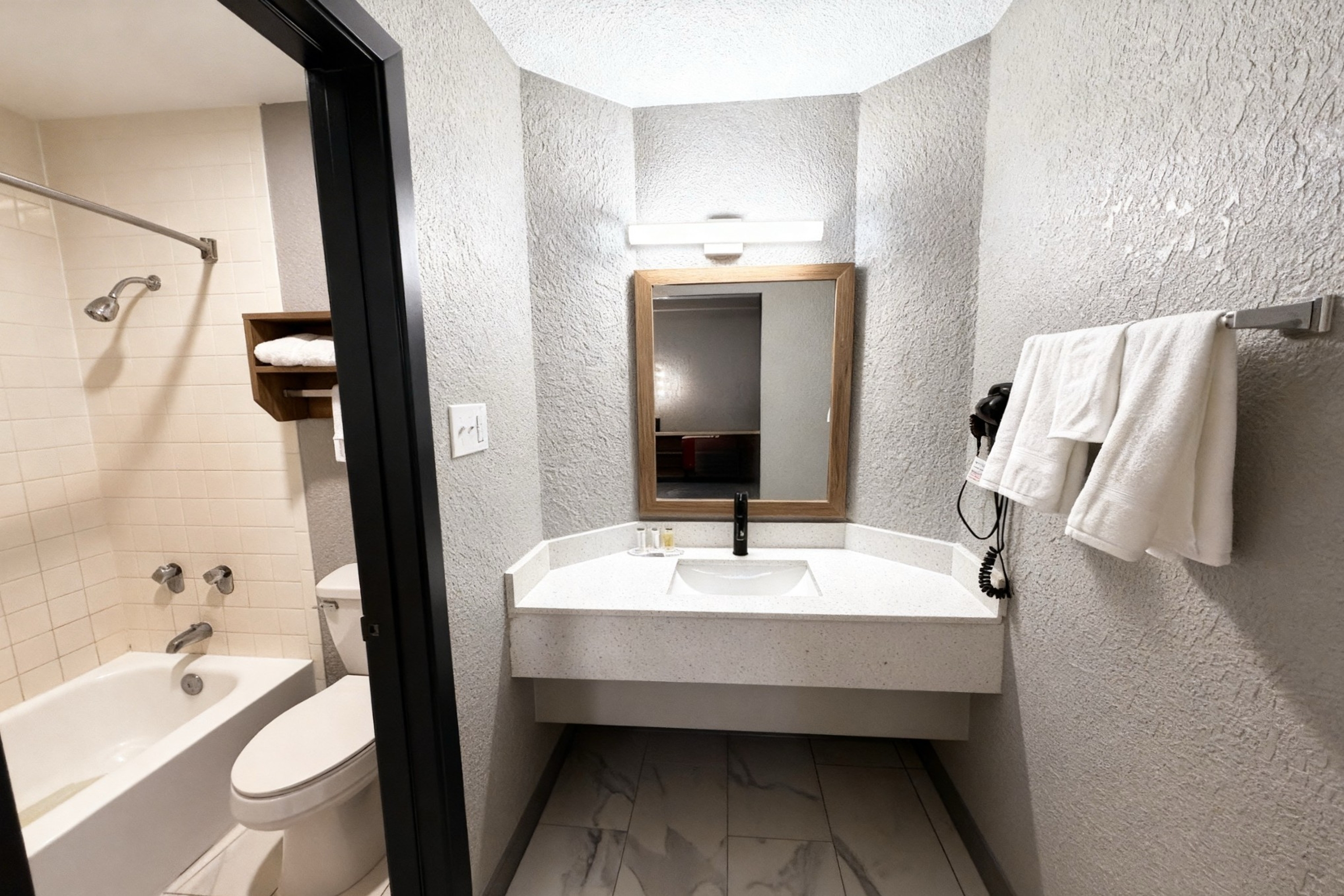 Guest room bath at the Super 8 by Wyndham Nacogdoches Near University in Nacogdoches, Texas