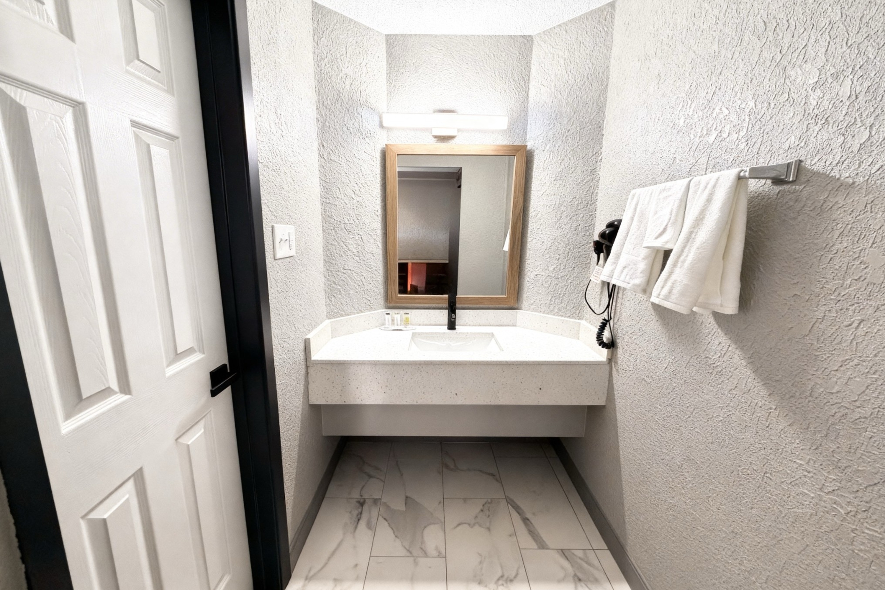 Guest room bath at the Super 8 by Wyndham Nacogdoches Near University in Nacogdoches, Texas