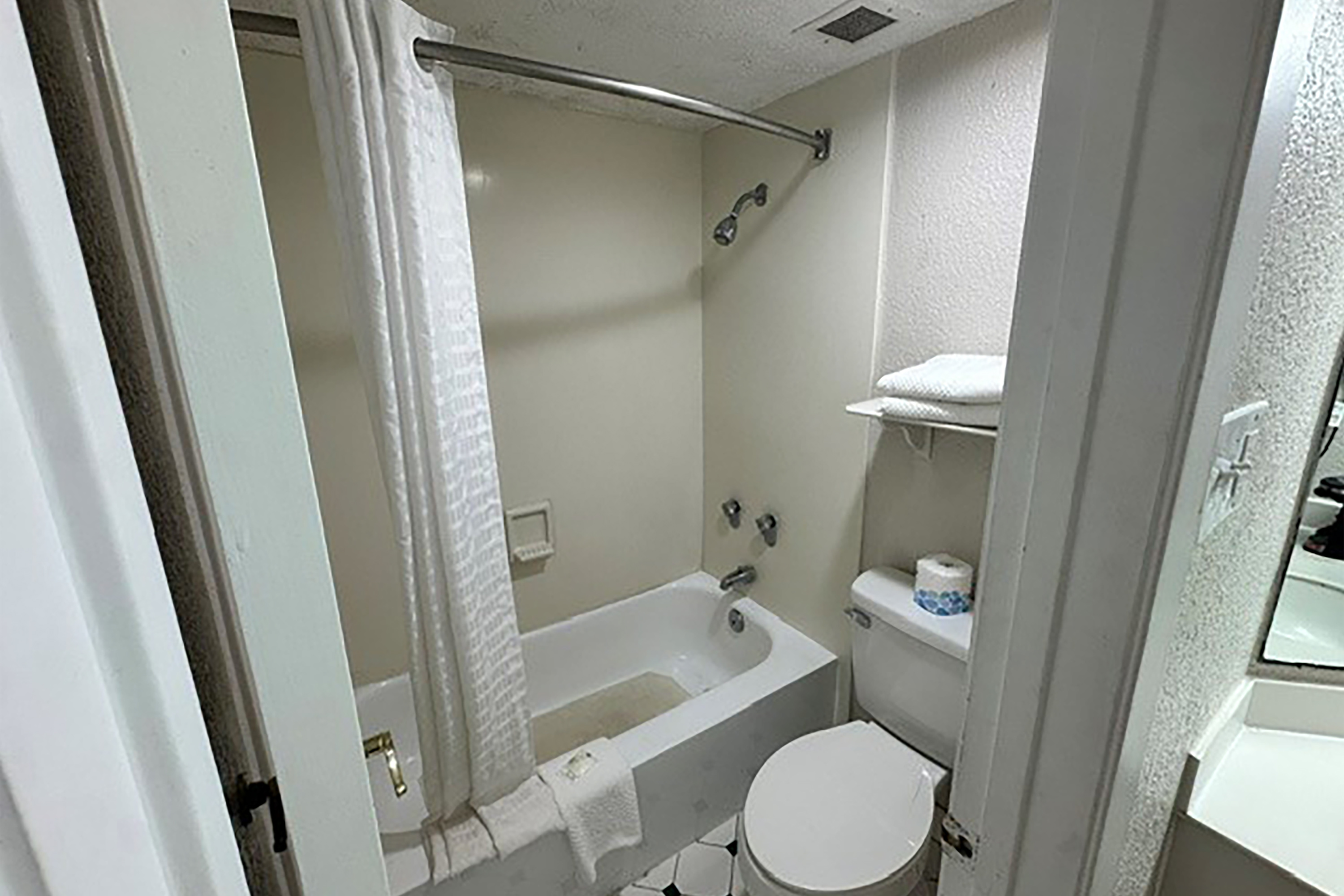 Guest room bath at the Super 8 by Wyndham Nacogdoches Near University in Nacogdoches, Texas