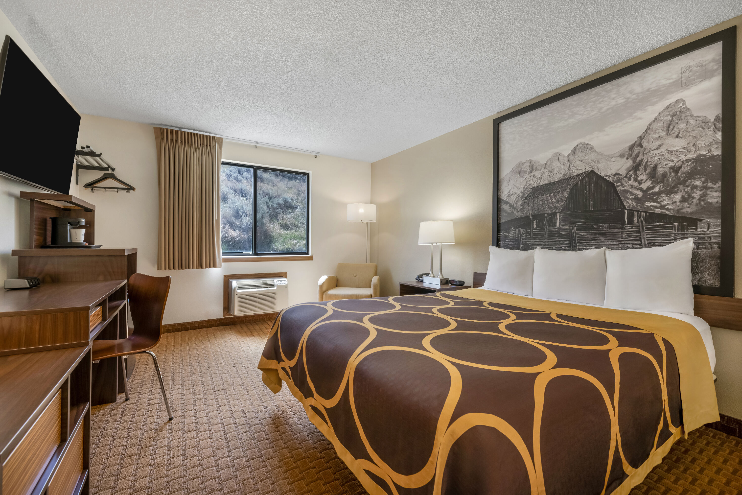 Queen bed guest room at the Super 8 by Wyndham Cody in Cody, Wyoming
