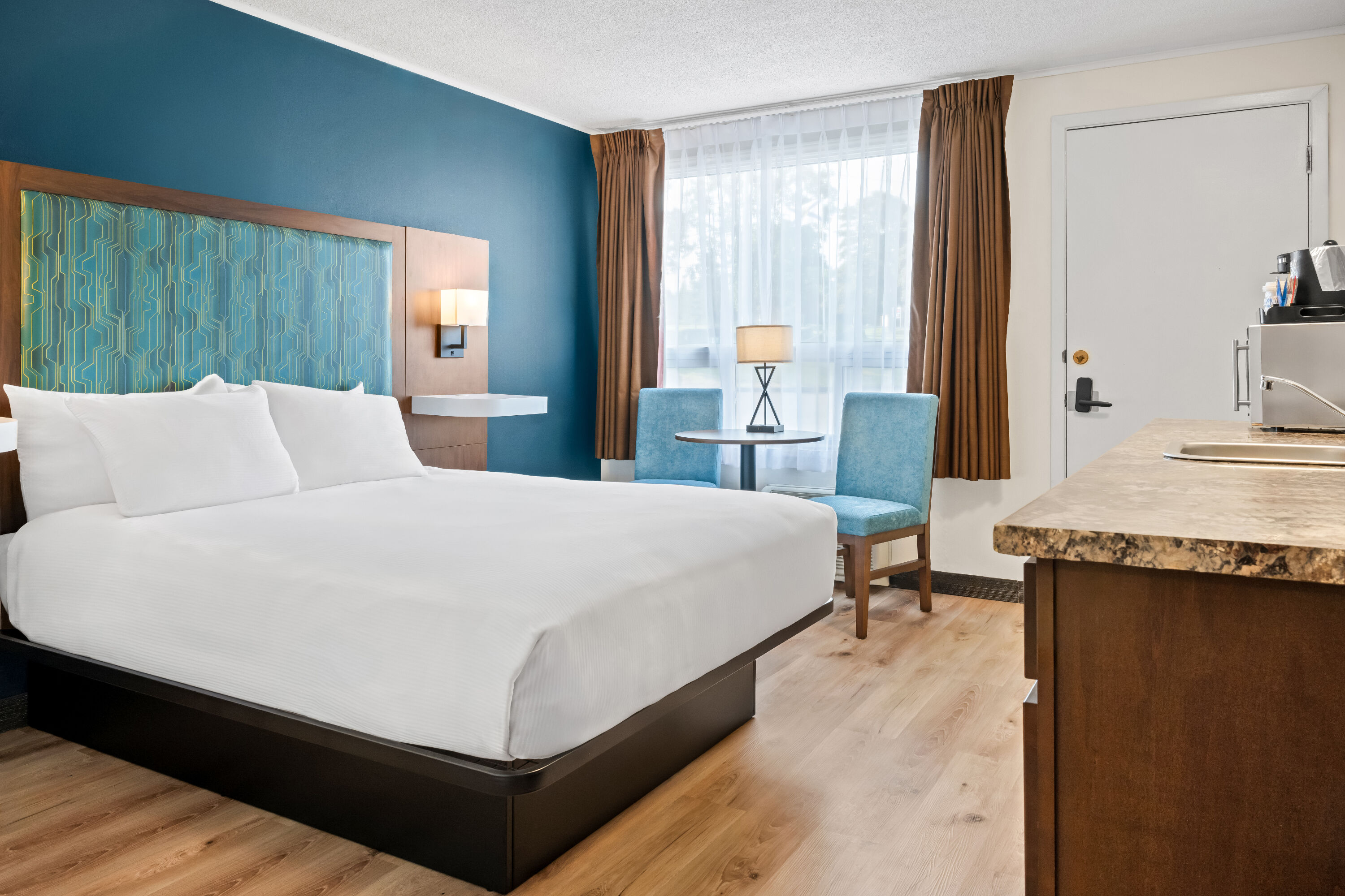 Queen bed guest room at the Travelodge by Wyndham Amherst in Amherst, Nova Scotia
