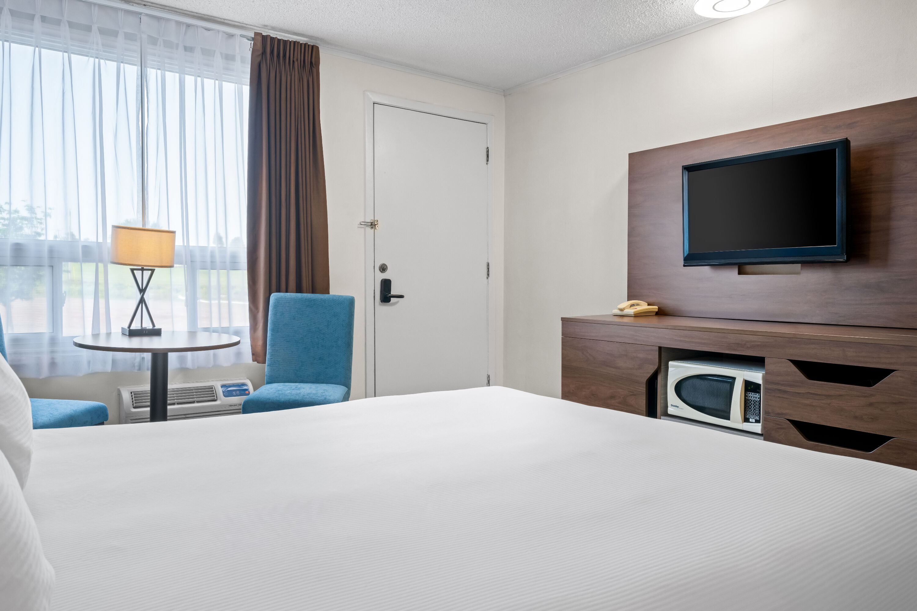 Queen bed guest room at the Travelodge by Wyndham Amherst in Amherst, Nova Scotia