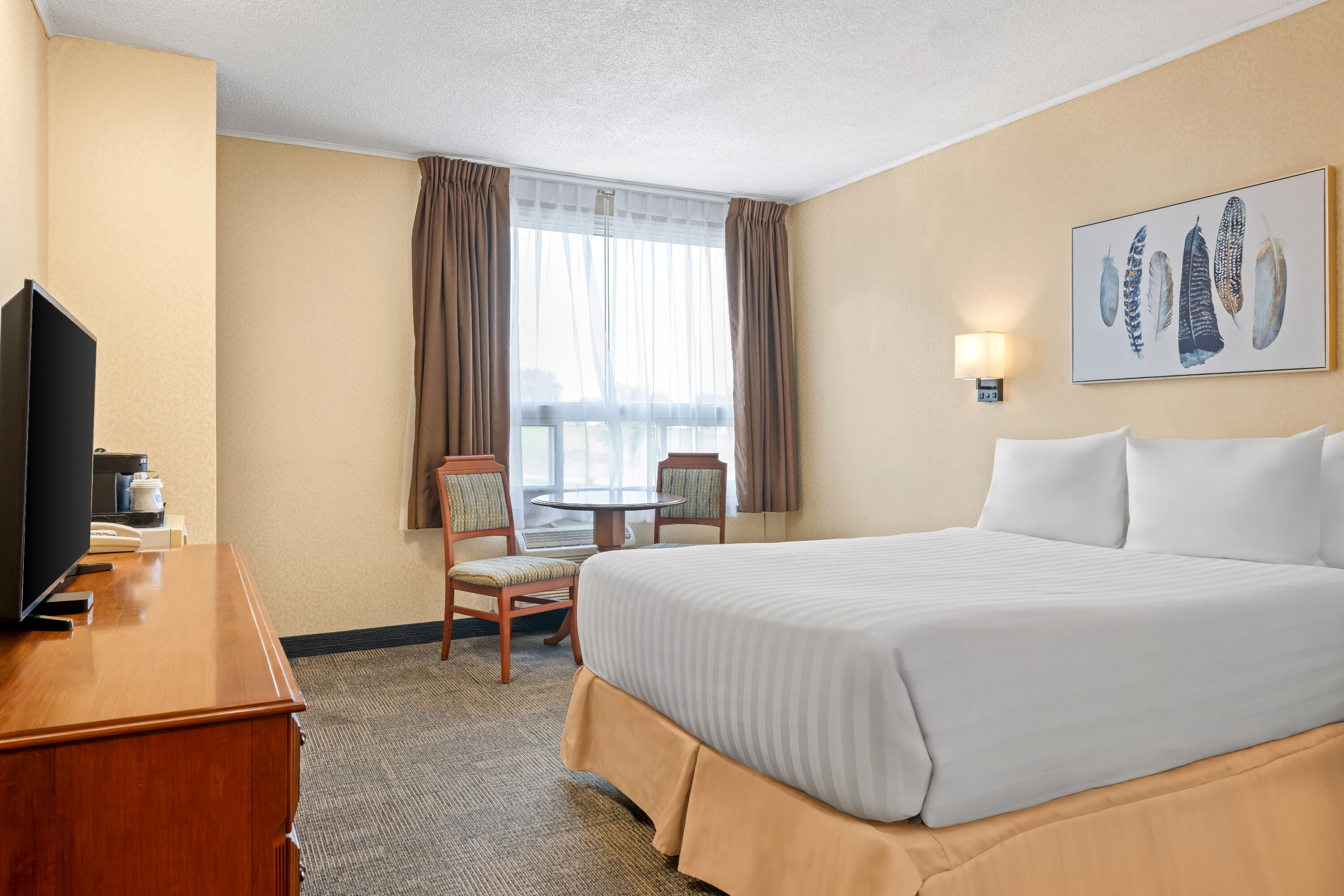 Queen bed guest room at the Travelodge by Wyndham Amherst in Amherst, Nova Scotia