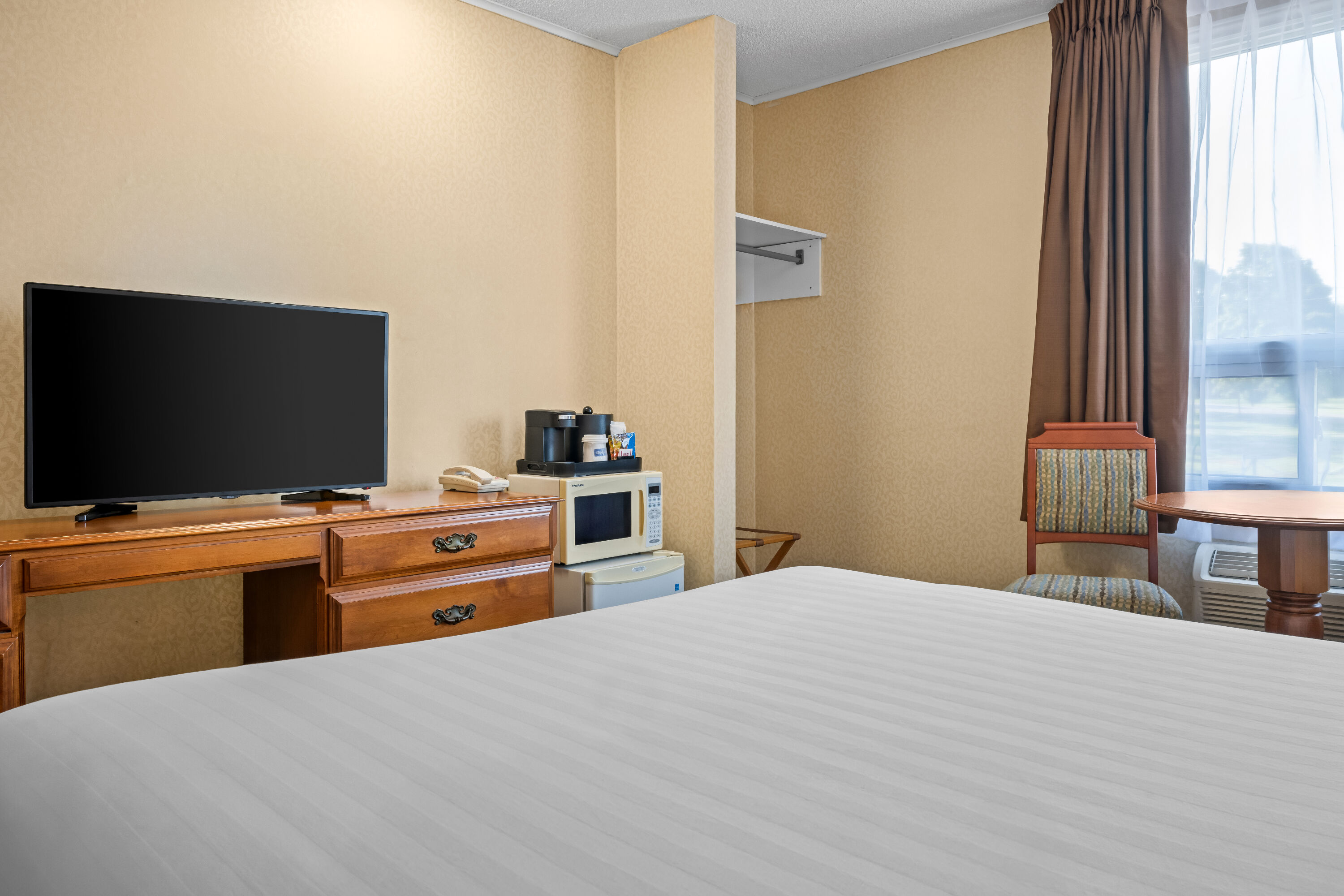 Queen bed guest room at the Travelodge by Wyndham Amherst in Amherst, Nova Scotia