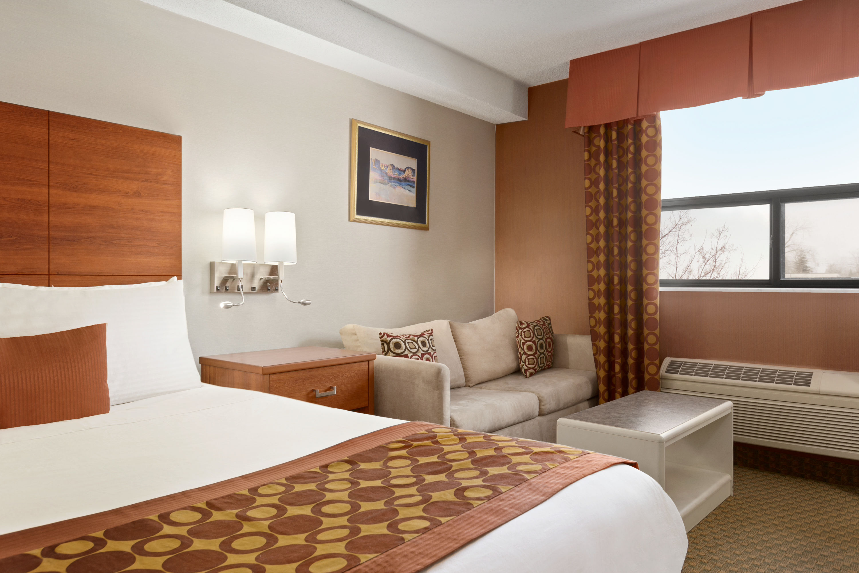 Queen bed guest room at the Travelodge by Wyndham Windsor in Windsor, Ontario