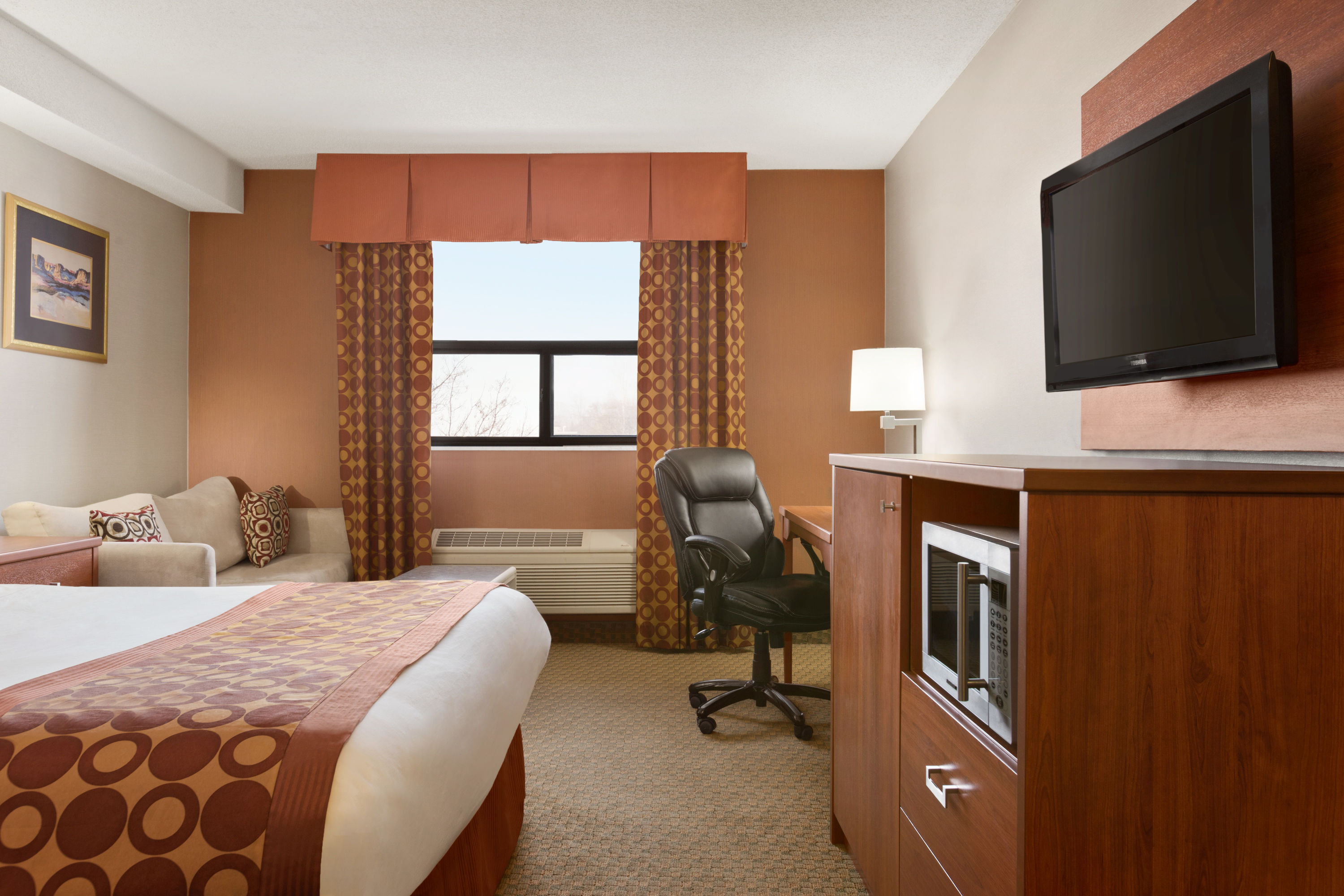 Queen bed guest room at the Travelodge by Wyndham Windsor in Windsor, Ontario