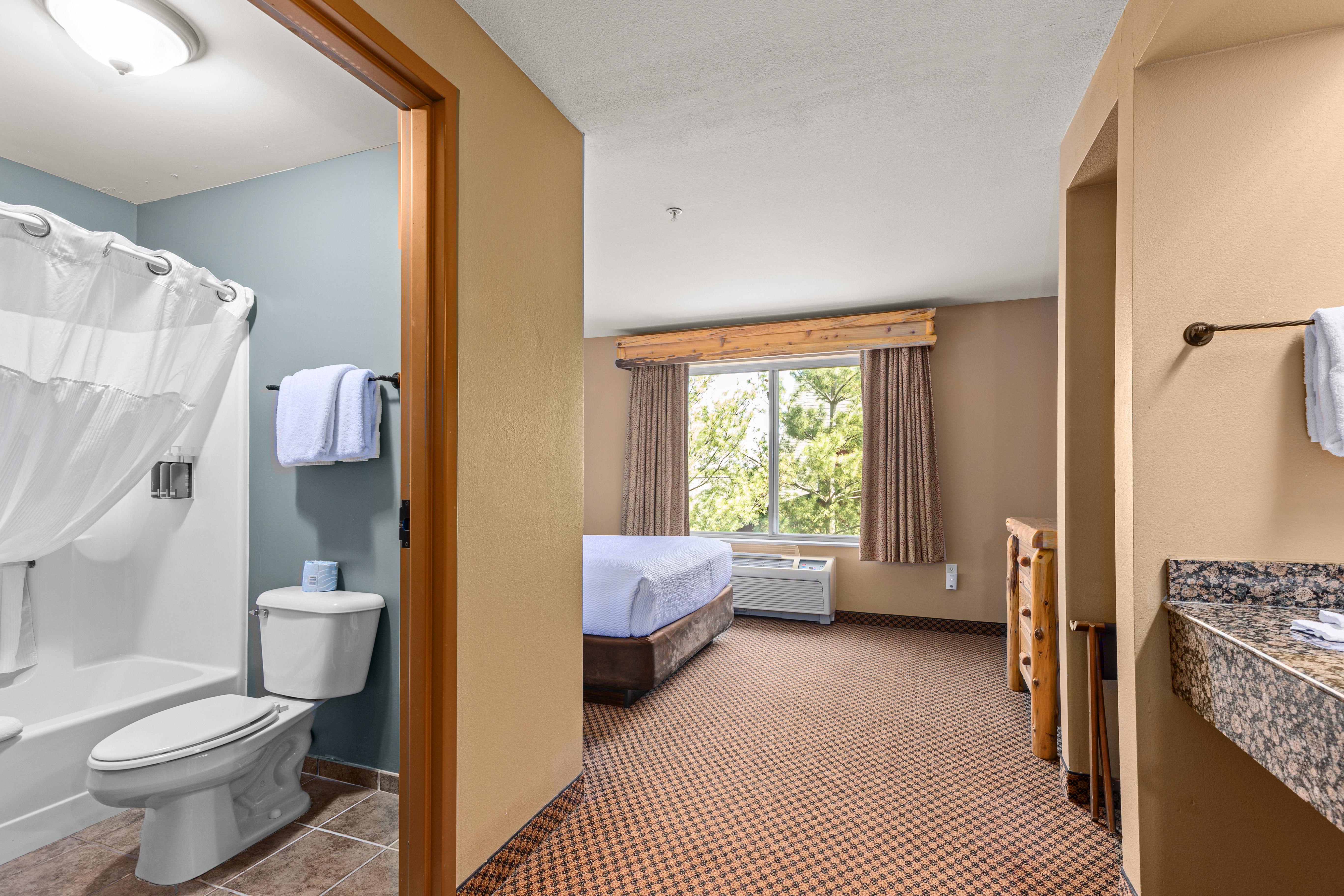 Queen bed guest room at the The Lodge at Brainerd Lakes, Trademark Collection by Wyndham in Baxter, Minnesota