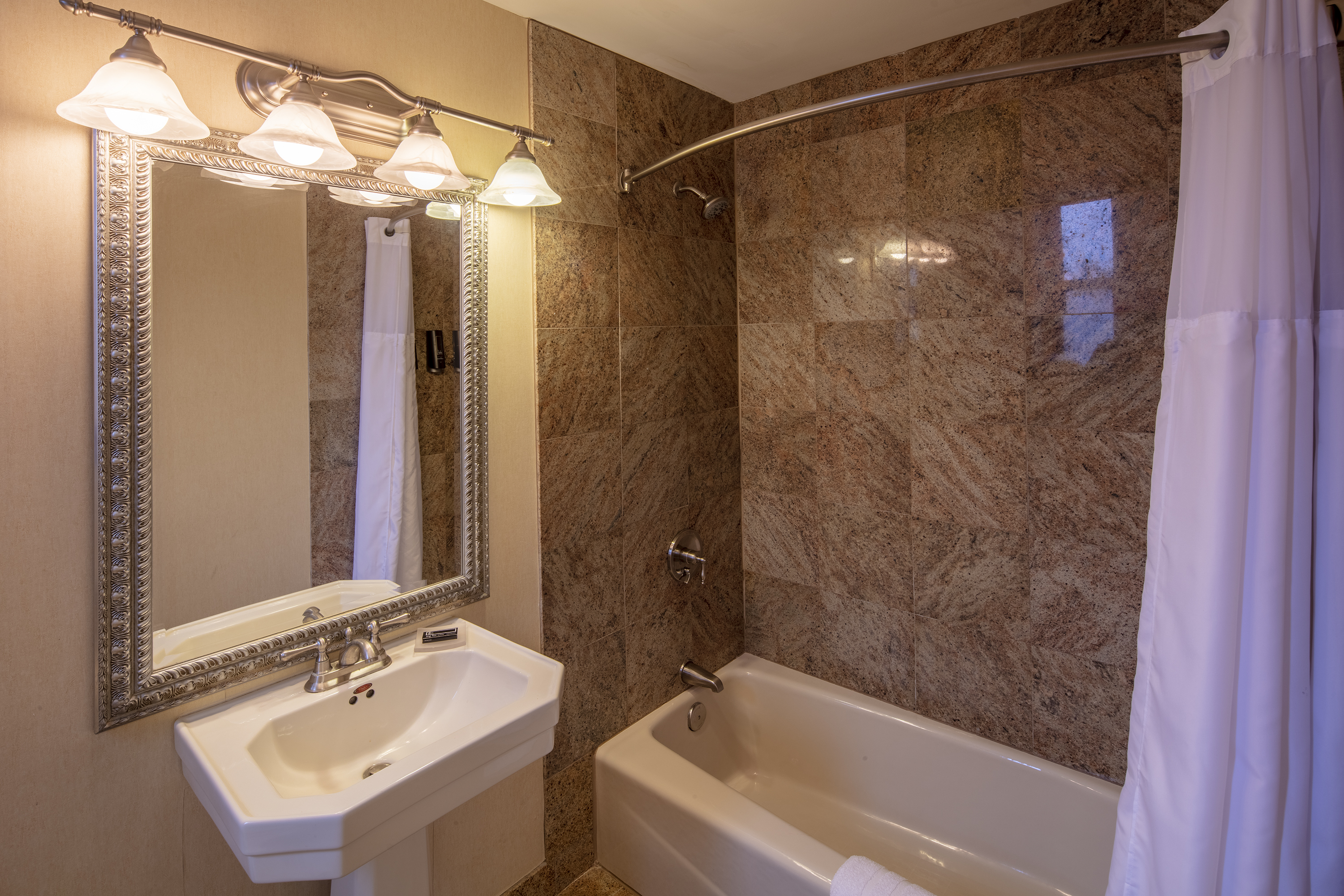 Guest room bath at the Collegian Hotel & Suites, Trademark Collection by Wyndham in Syracuse, New York